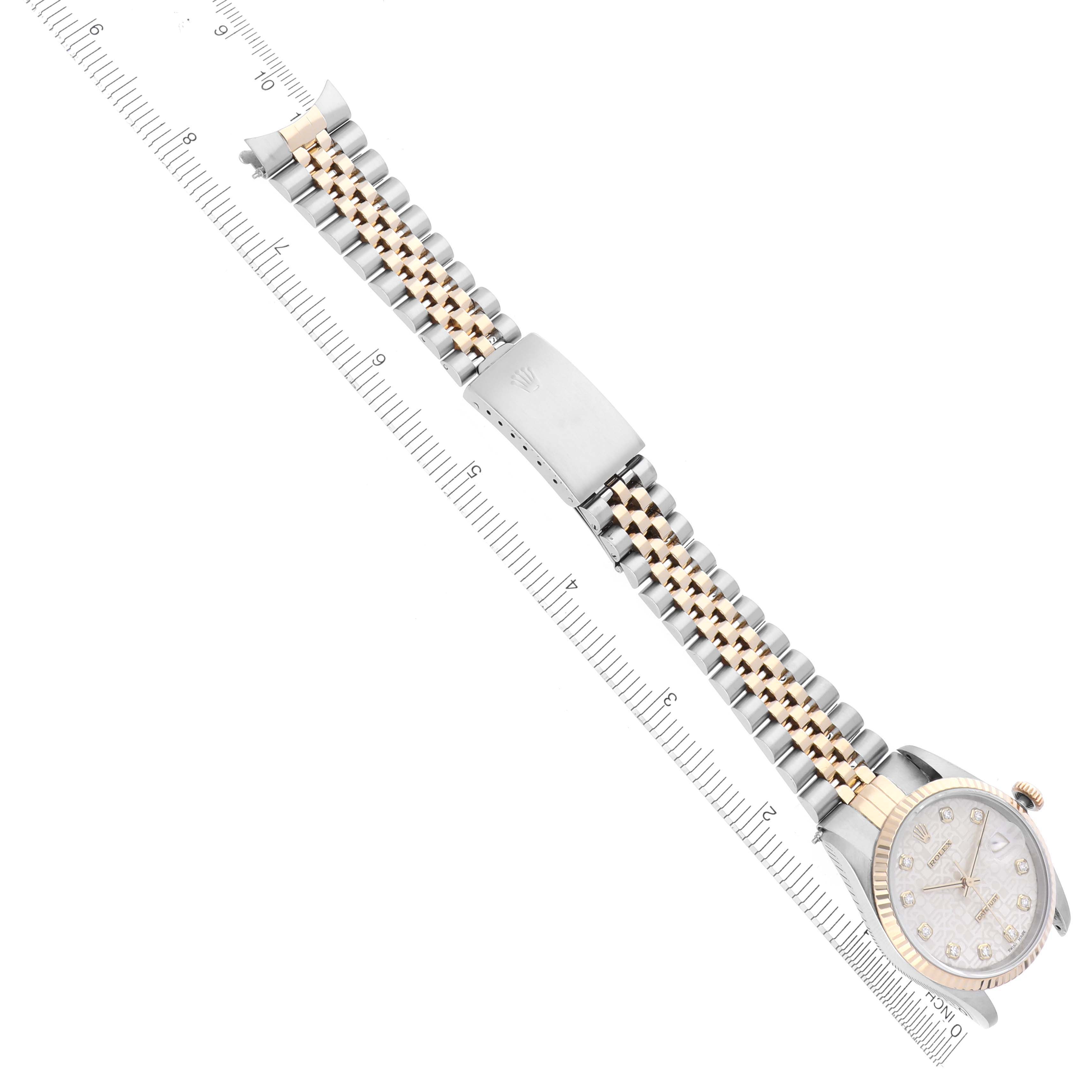 The Rolex Datejust 16233 Men
s Steel and Gold (two tone) White Dial 16233 Men
s Steel and Gold (two tone) White Dial watch is displayed flat, showcasing the face, bracelet, and clasp next to a ruler for scale.