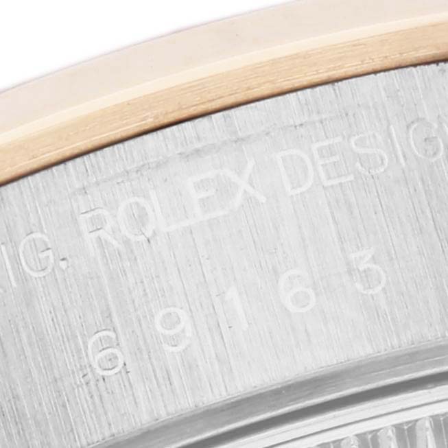 The image shows a close-up of the Rolex Datejust 69163 Women's Steel and Gold (two tone) Grey Dial 69163 Women's Steel and Gold (two tone) Grey Dial's case with engraved text and part of the bezel.