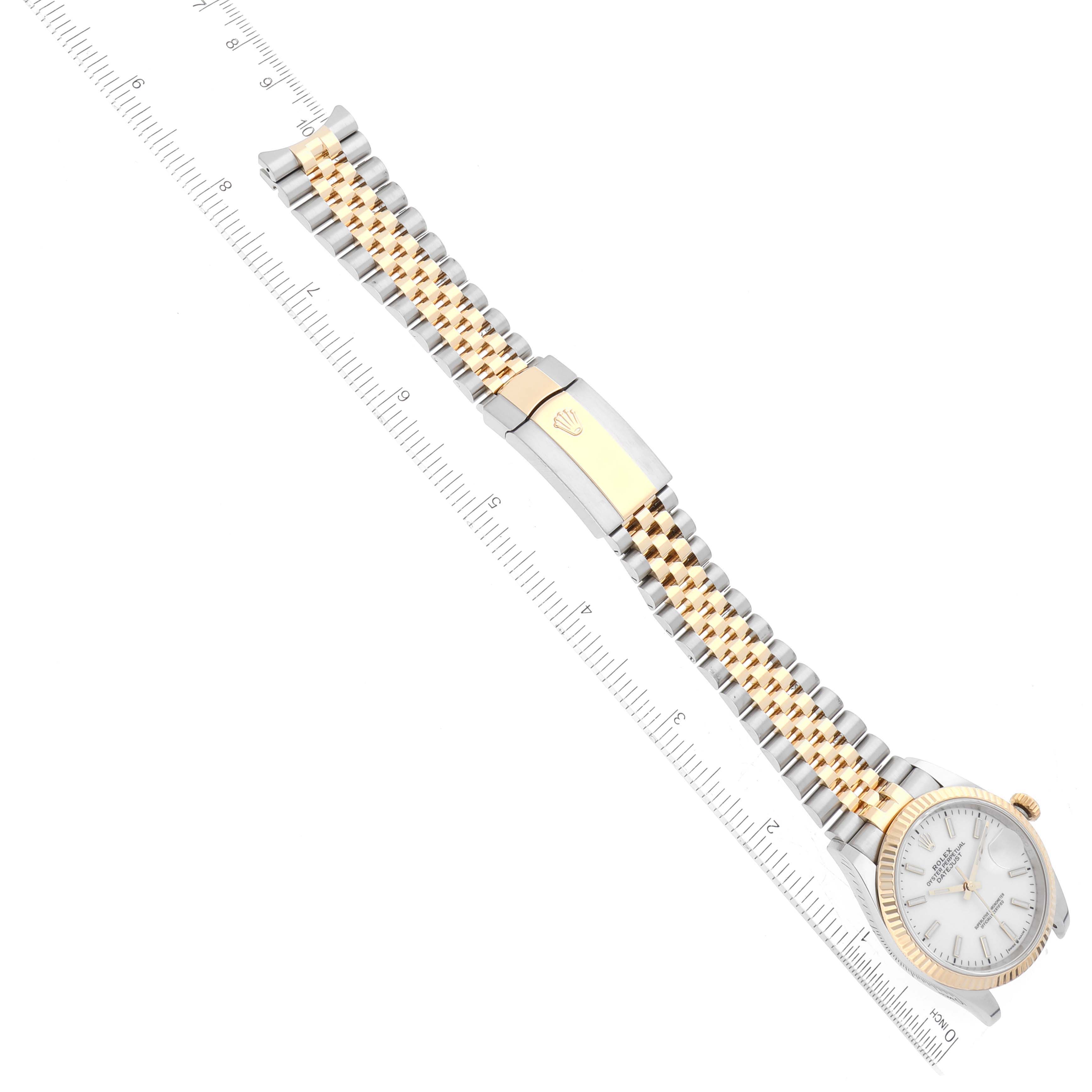 The image shows a top-down view of a Rolex Datejust 126233 Men's Steel and Gold (two tone) White Dial 126233 Men's Steel and Gold (two tone) White Dial watch, highlighting its face, bracelet, and clasp, with a ruler for scale.