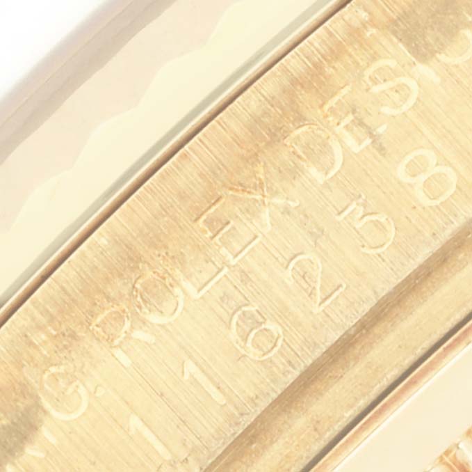 The image shows an angled close-up of the engraved inner bezel of a Rolex Datejust 116238 Men's Yellow Gold Mother of Pearl Dial 116238 Men's Yellow Gold Mother of Pearl Dial watch.