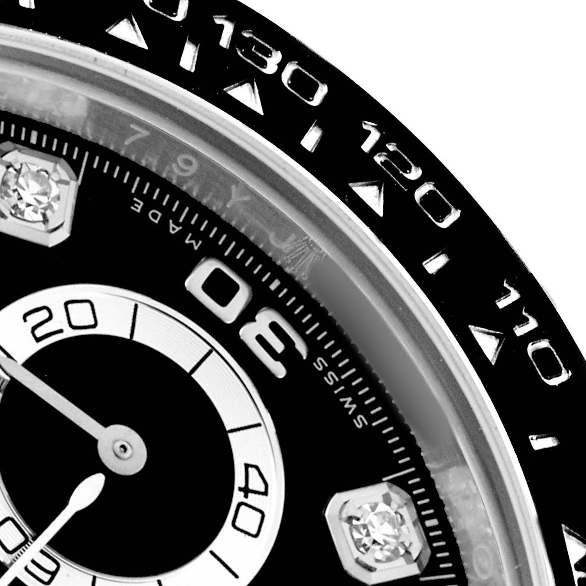 The image shows a close-up of the Rolex Daytona 116519 Men
s White Gold Black Dial watch face, highlighting the bezel, part of the dial, and a sub-dial.