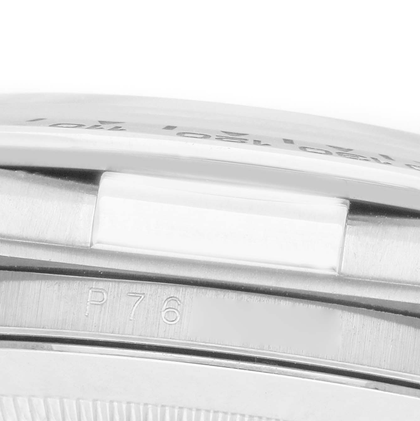The image shows a close-up of the side of a Rolex Daytona 116519 Men
s White Gold White Dial watch, focusing on the bezel with engraved markings.