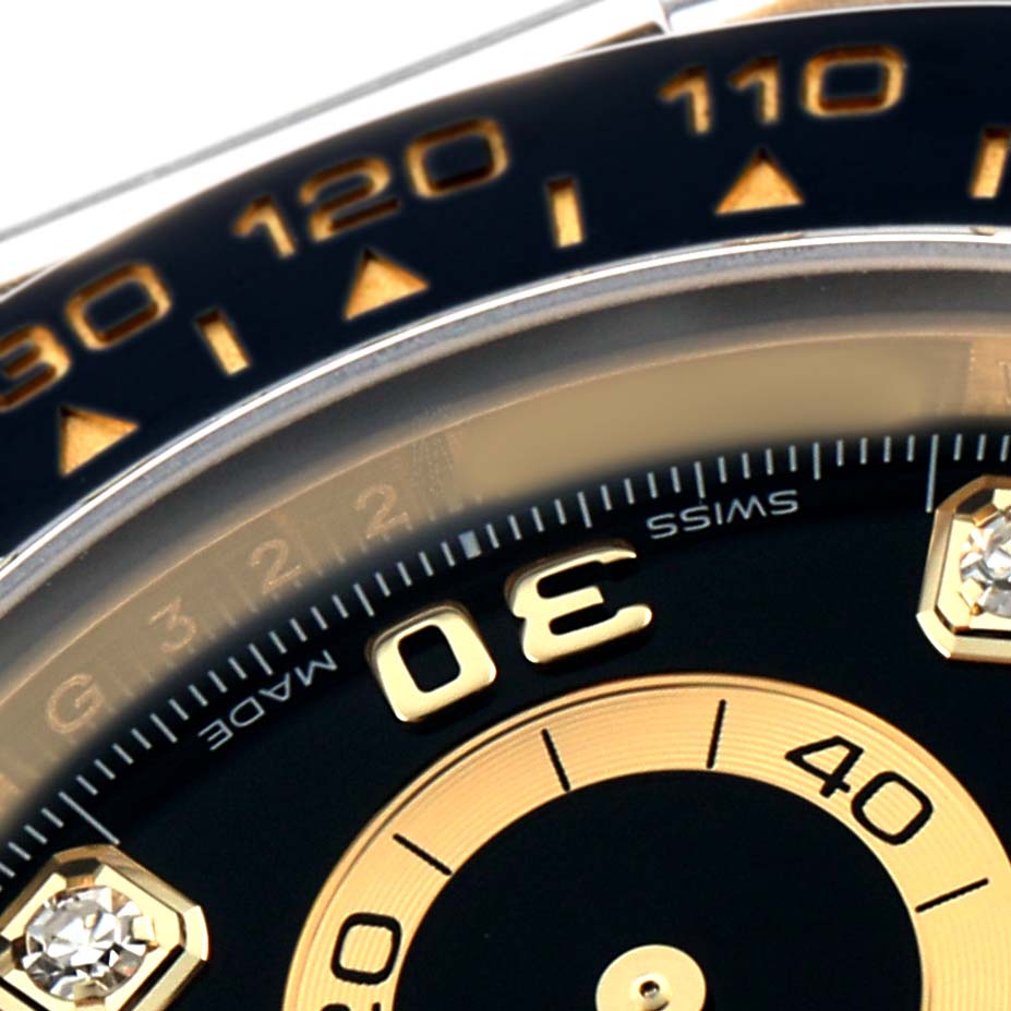 The image shows a close-up of the bezel and dial of a Rolex Daytona 116518 Men
s Yellow Gold Beige Dial watch, showcasing the tachymetric scale and part of the face.