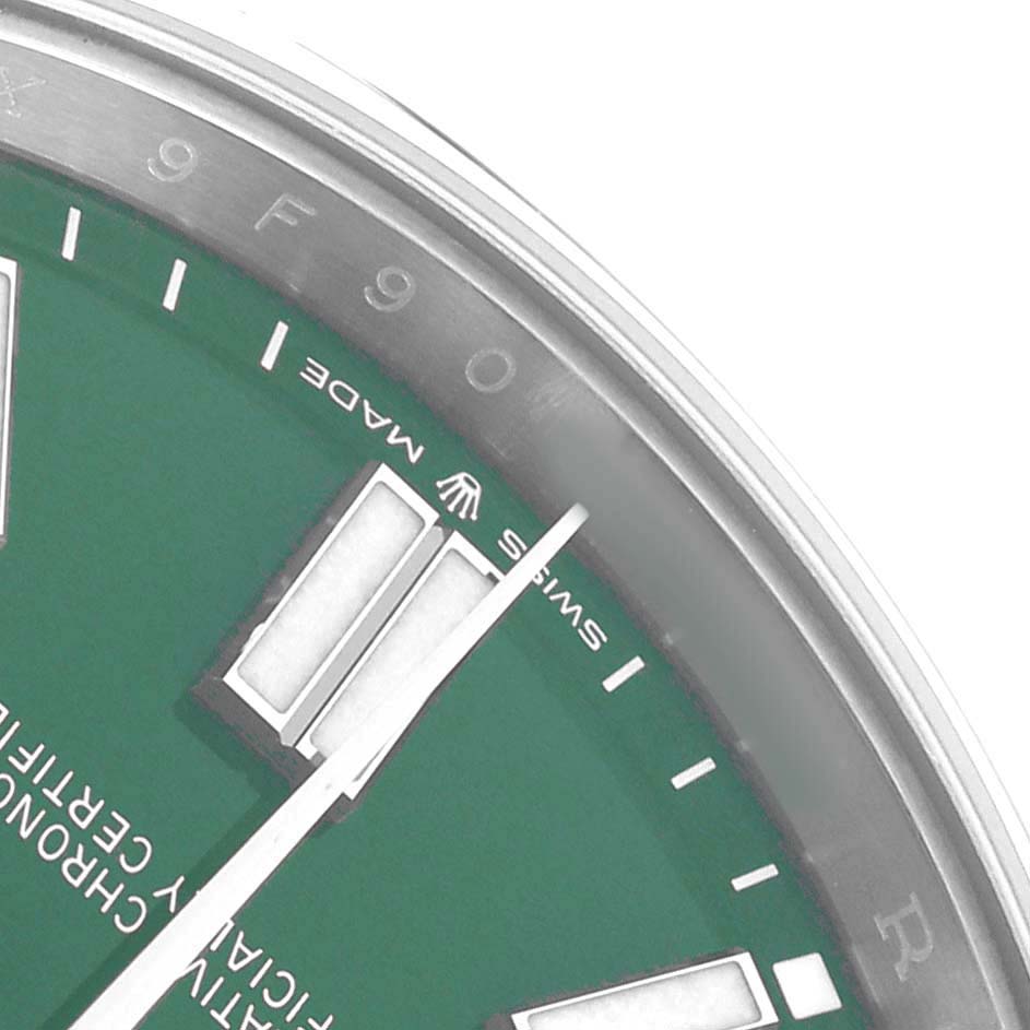 The image shows a close-up of the green dial, hands, and part of the bezel of a Rolex Oyster Perpetual 124300 Men
s Stainless Steel Green Dial watch.