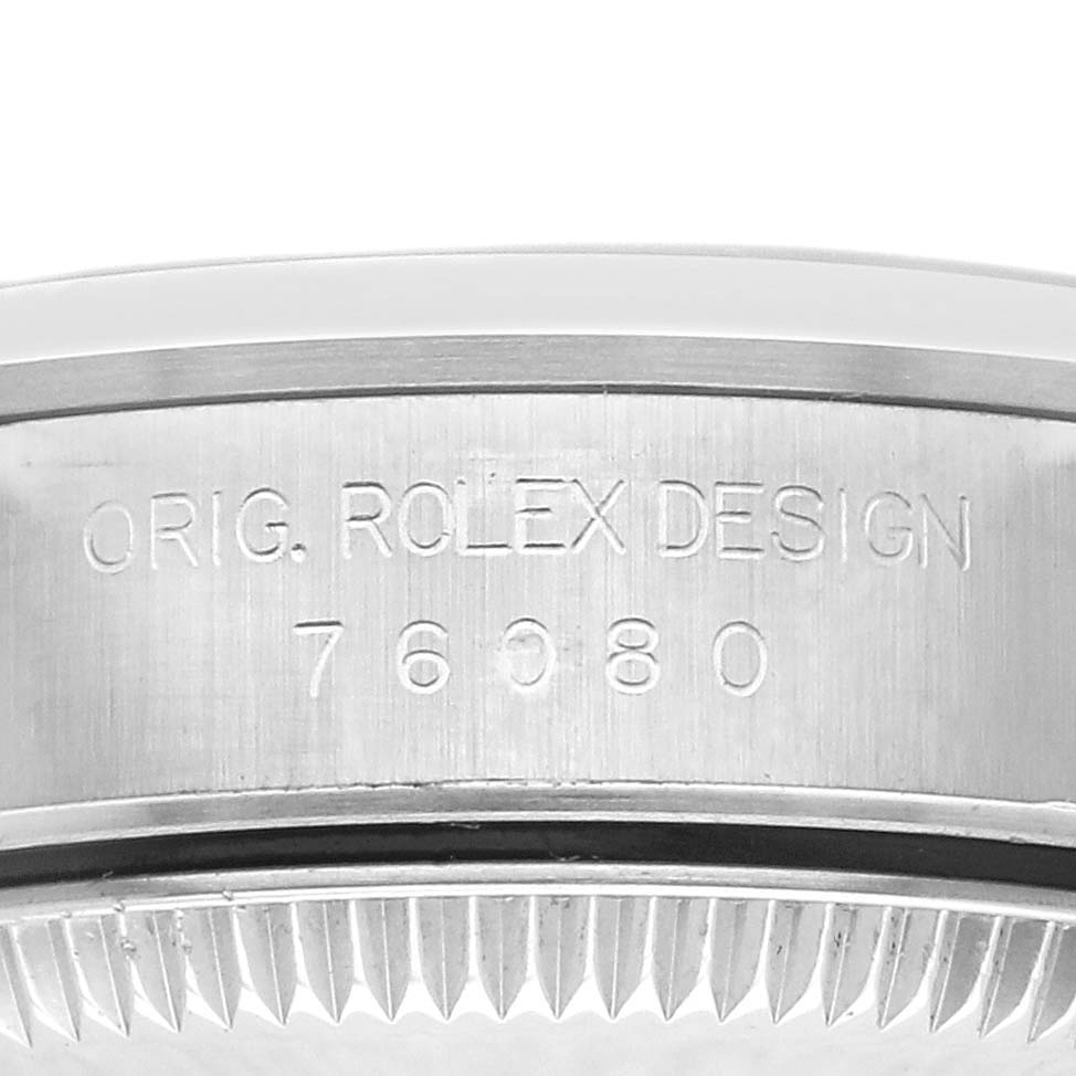 The image shows the side of a Rolex Oyster Perpetual 76080 Women's Stainless Steel Pink Dial 76080 Women's Stainless Steel Pink Dial with engraved model details.