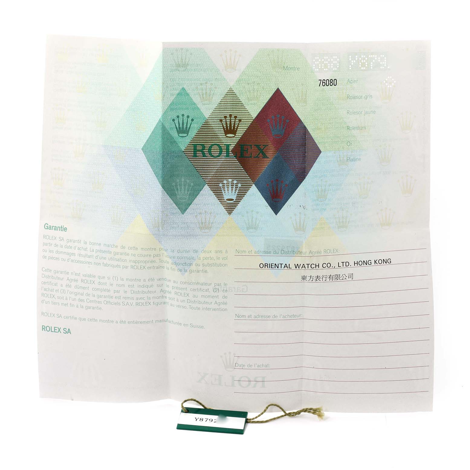 The image shows a warranty card and a green tag for a Rolex Oyster Perpetual 76080 Women
s Stainless Steel Pink Dial 76080 Women
s Stainless Steel Pink Dial watch from an overhead angle.