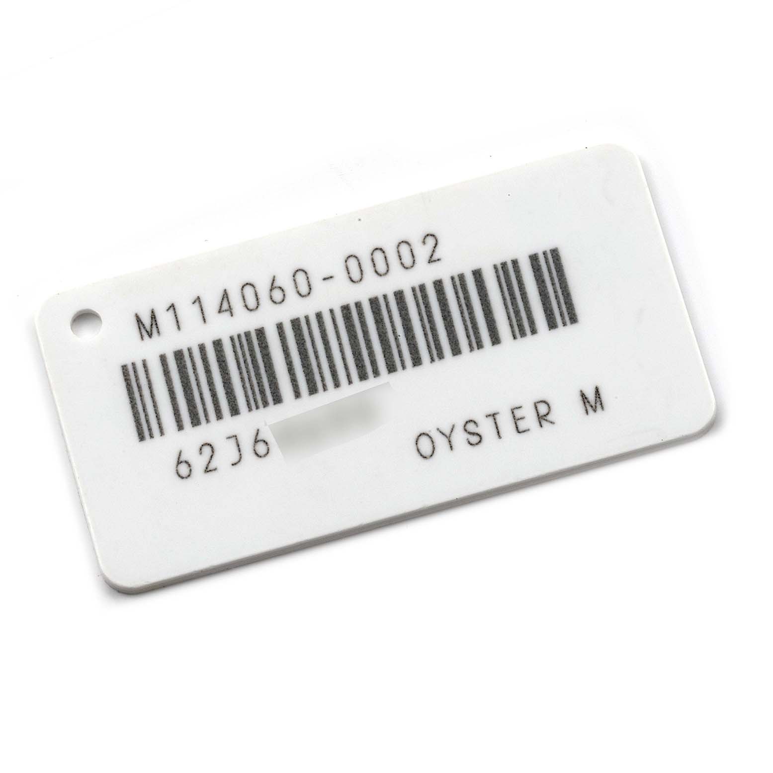 The image shows a tag associated with the Rolex Submariner 114060 Men
s Stainless Steel Black Dial 114060 Men
s Stainless Steel Black Dial model, displaying a barcode, serial number, and "Oyster M" designation.
