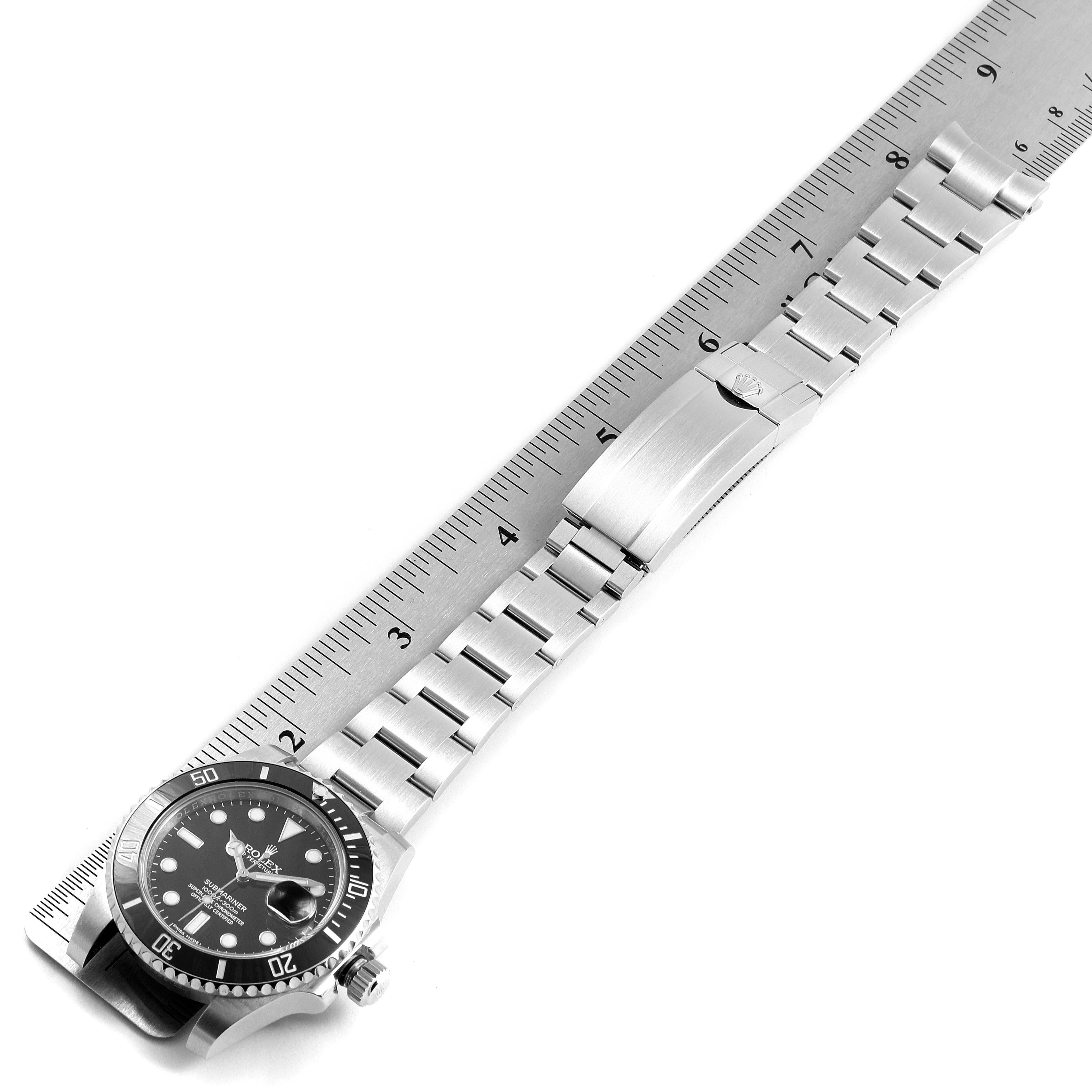 The image shows a side view of the Rolex Submariner 116610 Men's Stainless Steel Black Dial 116610 Men's Stainless Steel Black Dial watch, highlighting the dial, bezel, and bracelet laid next to a ruler.