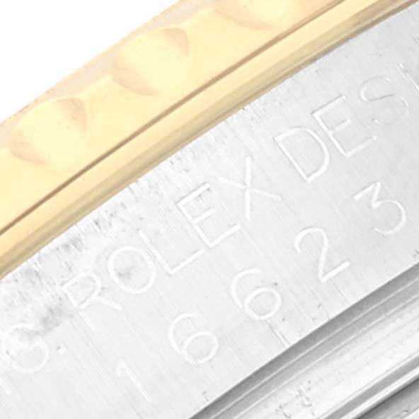 This close-up image of a Rolex Yacht-Master 16623 Men's Steel and Gold (two tone) Champagne Dial 16623 Men's Steel and Gold (two tone) Champagne Dial watch shows a portion of the gold bezel and engraved text on the case side.