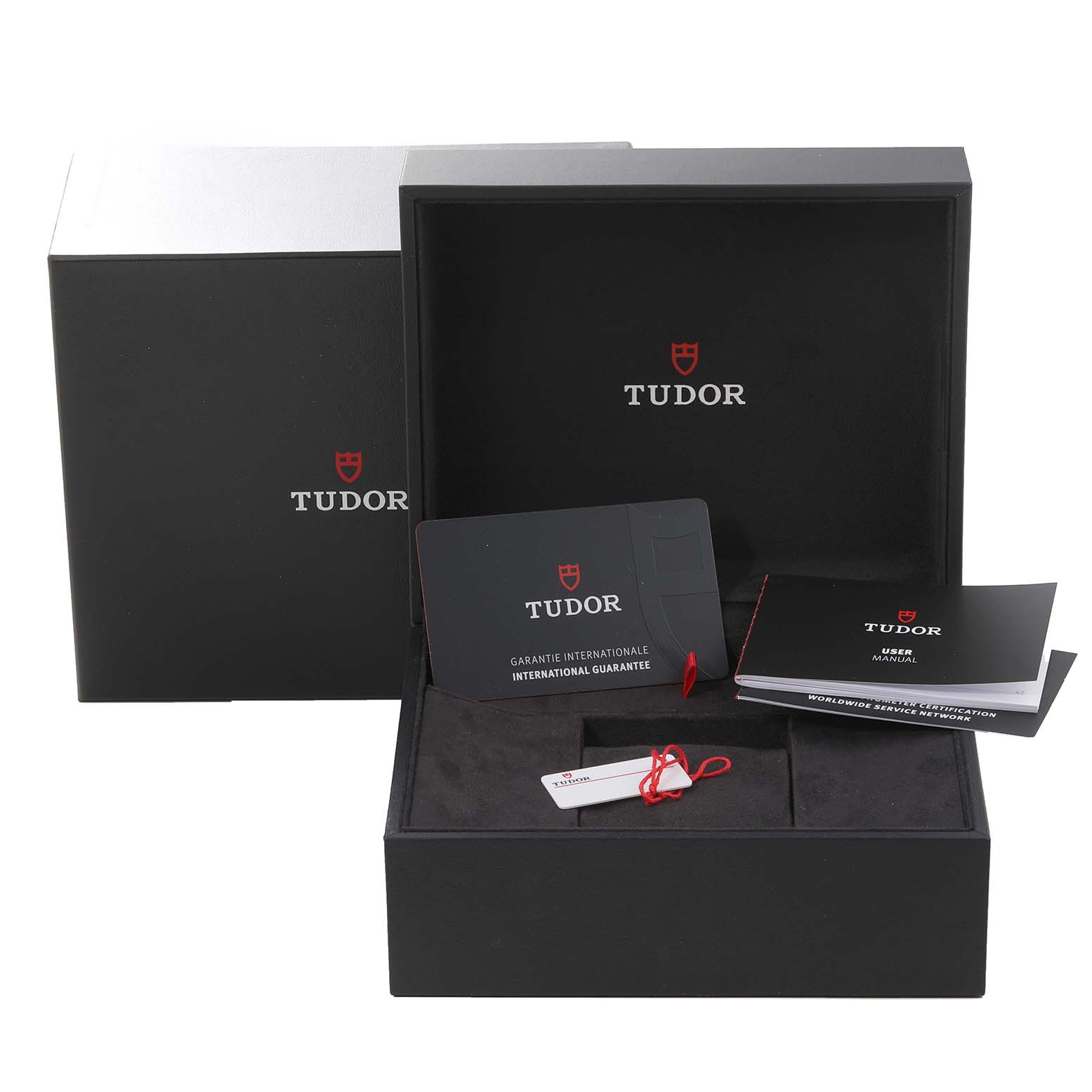 The image shows the Tudor Heritage Black Bay M79030N-0001 Men
s Stainless Steel Black Dial M79030N-0001 Men
s Stainless Steel Black Dial watch packaging, international guarantee card, user manual, and hang tag from a front angle.
