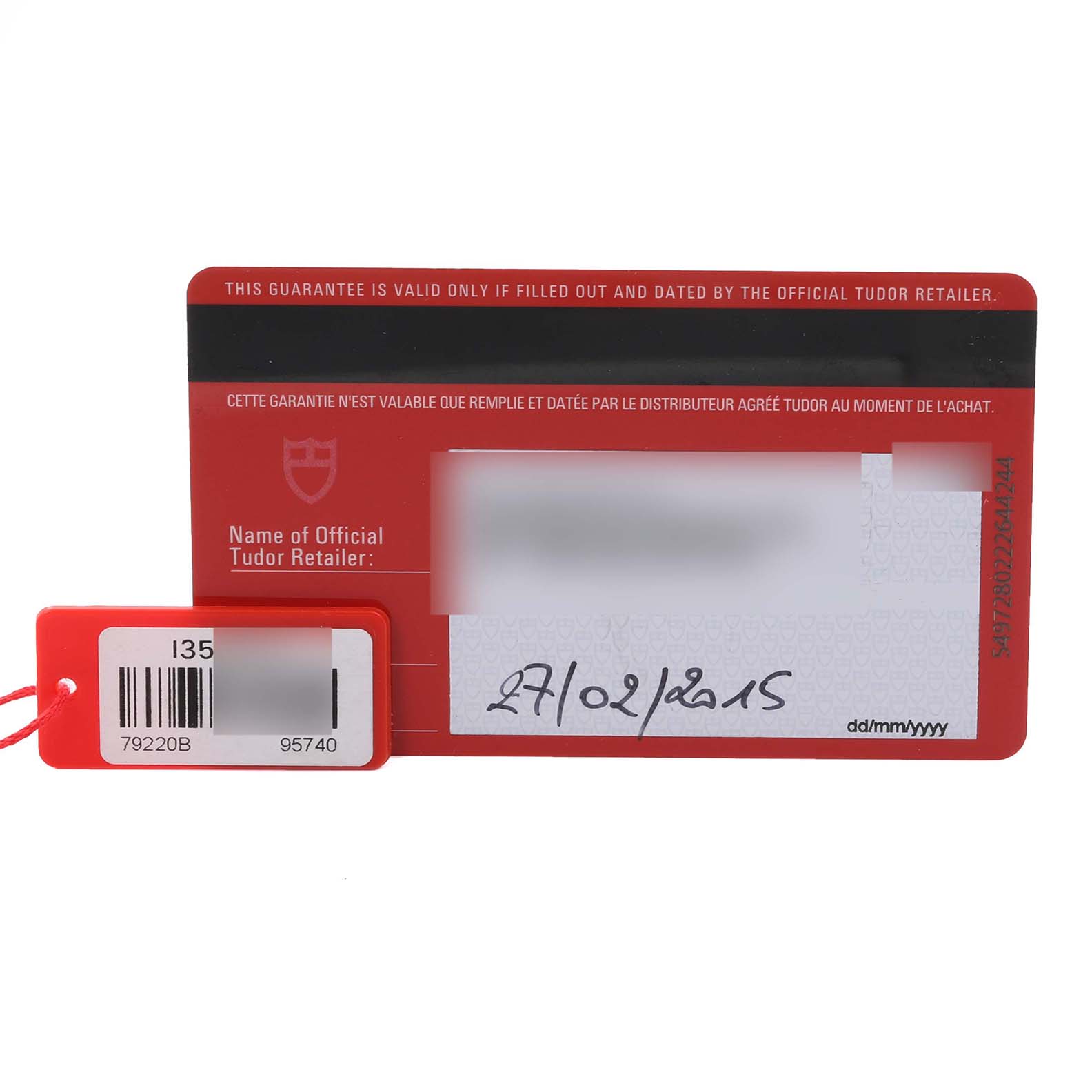 The image shows a Tudor Heritage Black Bay 79220B Men
s Stainless Steel Black Dial 79220B Men
s Stainless Steel Black Dial guarantee card with a barcode tag attached.