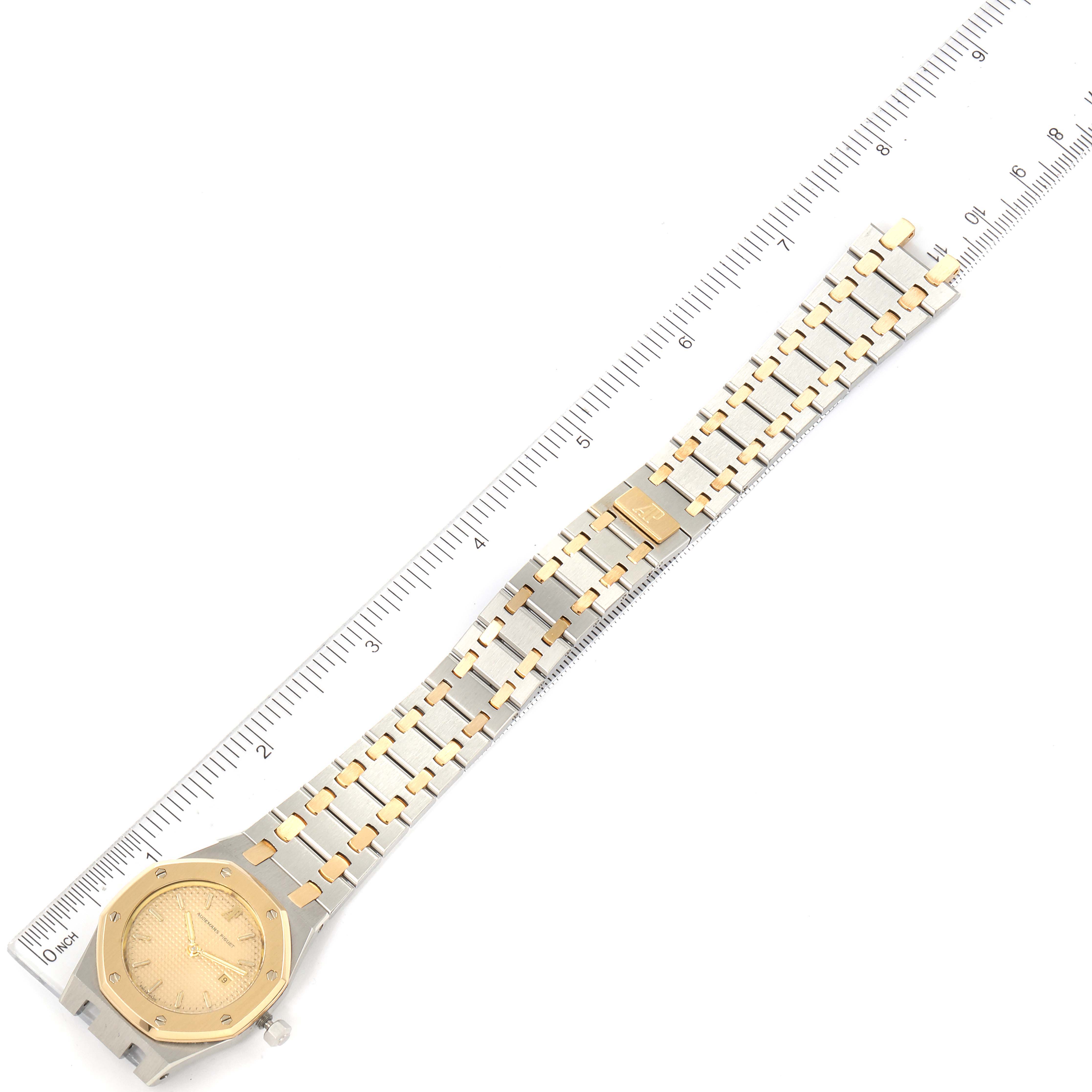 The image shows a top-down view of an Audemars Piguet Royal Oak 6271SA/902 Women's Steel and Gold (two tone) Champagne Dial 6271SA/902 Women's Steel and Gold (two tone) Champagne Dial watch, focusing on its dial, bracelet, and a ruler for size reference.