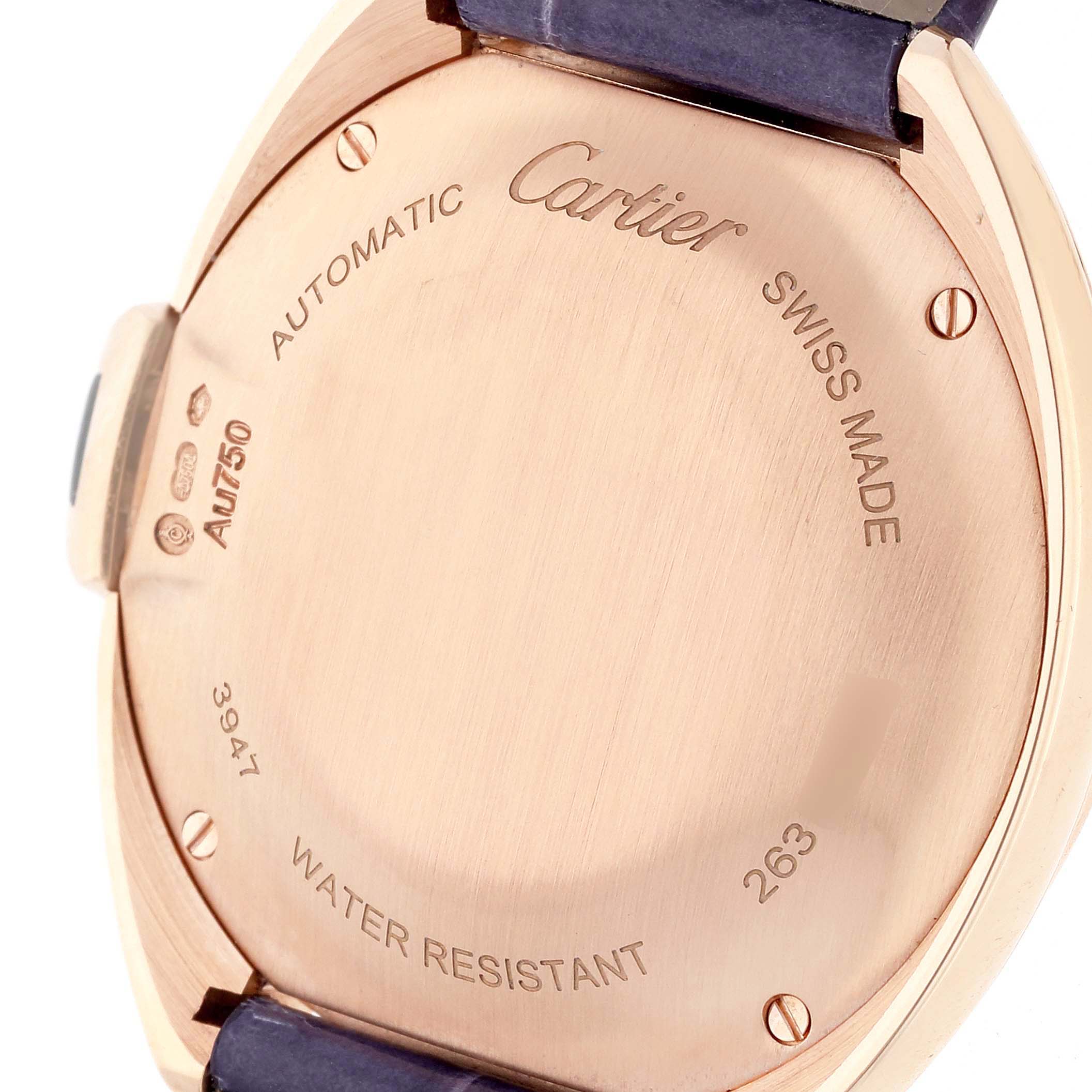 The image shows the back case of the Cartier Clé model watch, highlighting its markings and leather strap attachment.