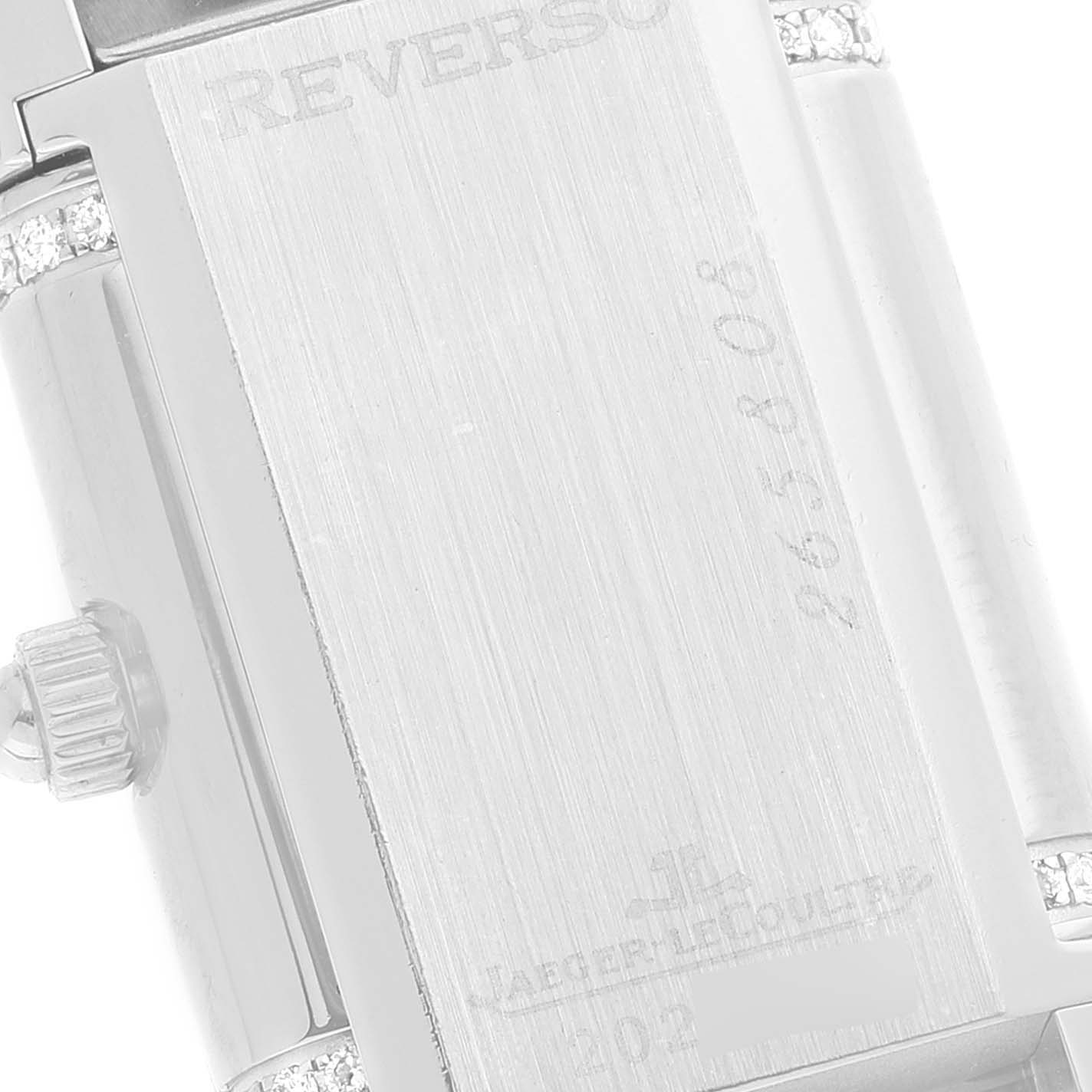 This close-up image of a Jaeger LeCoultre Reverso 265.8.08 Women's Stainless Steel Silver Dial 265.8.08 Women's Stainless Steel Silver Dial watch shows the engraved back case and crown.