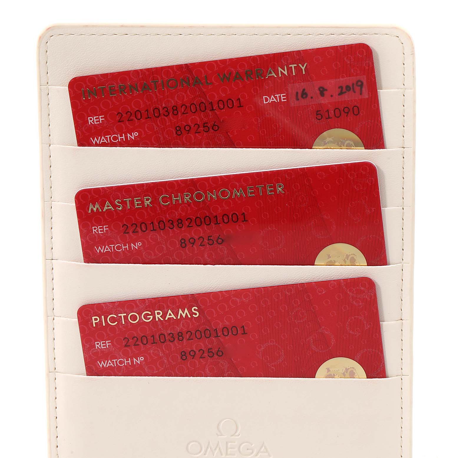 The image shows warranty cards and certification cards for the Omega Aqua Terra 220.10.38.20.01.001 Men's Stainless Steel Black Dial 220.10.38.20.01.001 Men's Stainless Steel Black Dial model, arranged in a card holder.