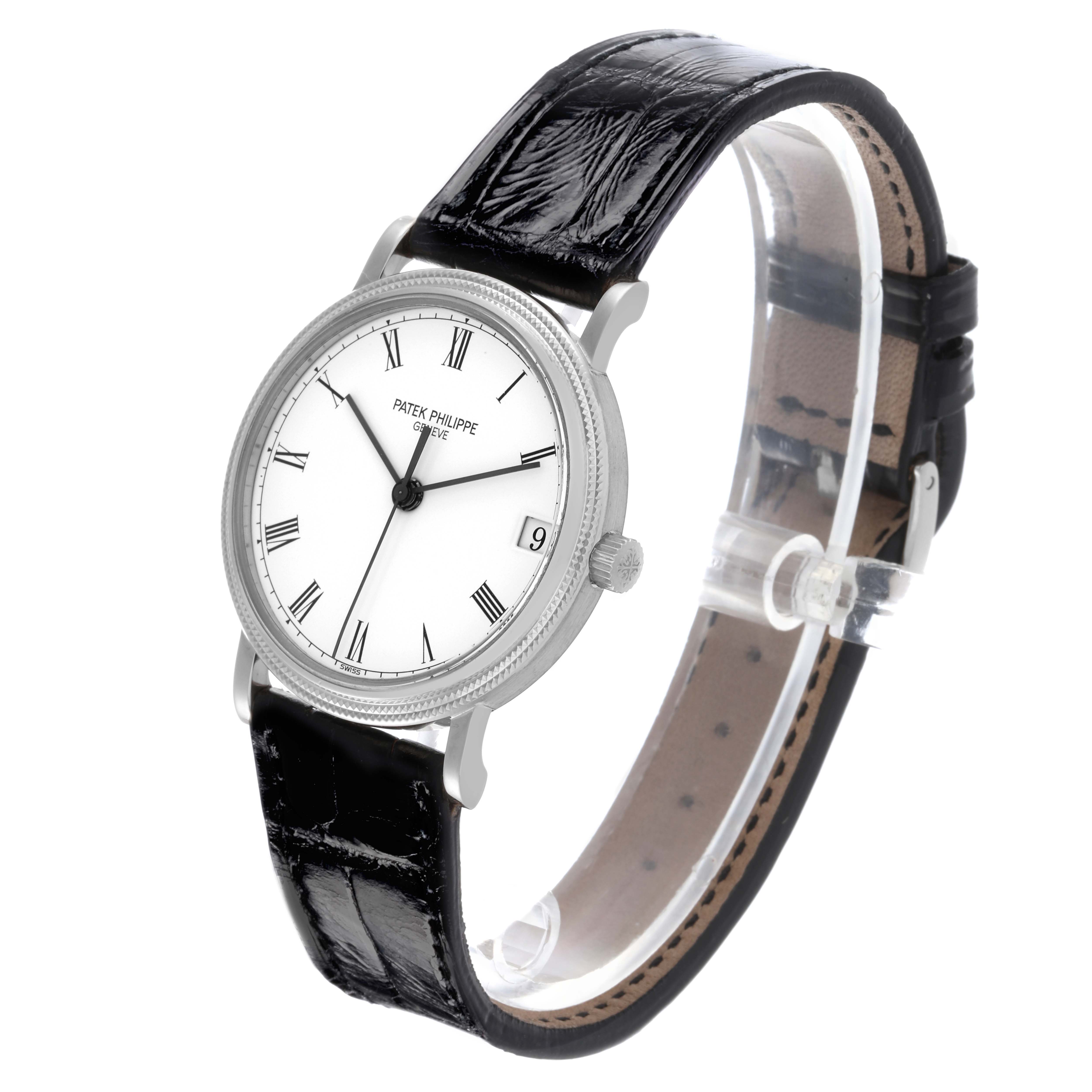 The Patek Philippe Calatrava 3802/200G-001 Men
s White Gold White Dial 3802/200G-001 Men
s White Gold White Dial watch is shown at an oblique angle, highlighting its face, black strap, case, and crown.