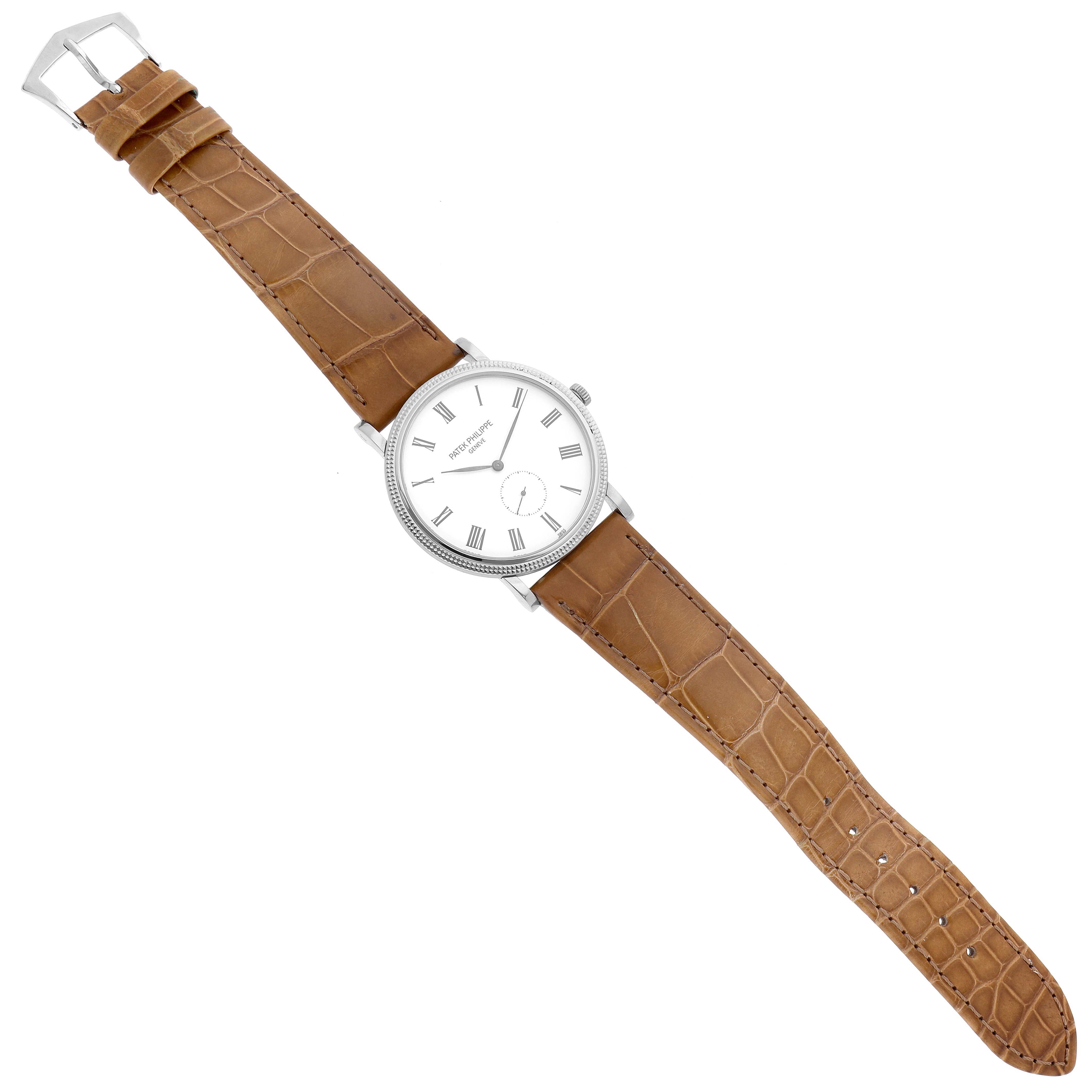The image shows a top view of the Patek Philippe Calatrava 5119G-001 Men
s White Gold White Dial 5119G-001 Men
s White Gold White Dial watch with a brown leather strap and Roman numeral dial.