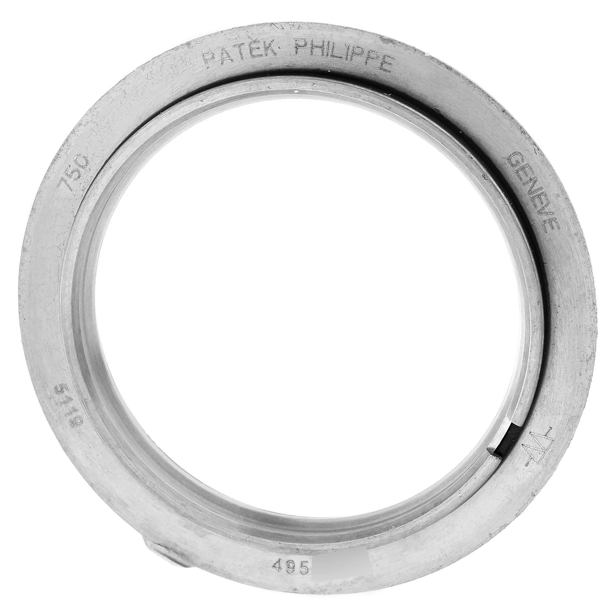 This image shows a Patek Philippe Calatrava 5119G-001 Men
s White Gold White Dial 5119G-001 Men
s White Gold White Dial watch bezel from a top-down angle, highlighting the brand engraving.