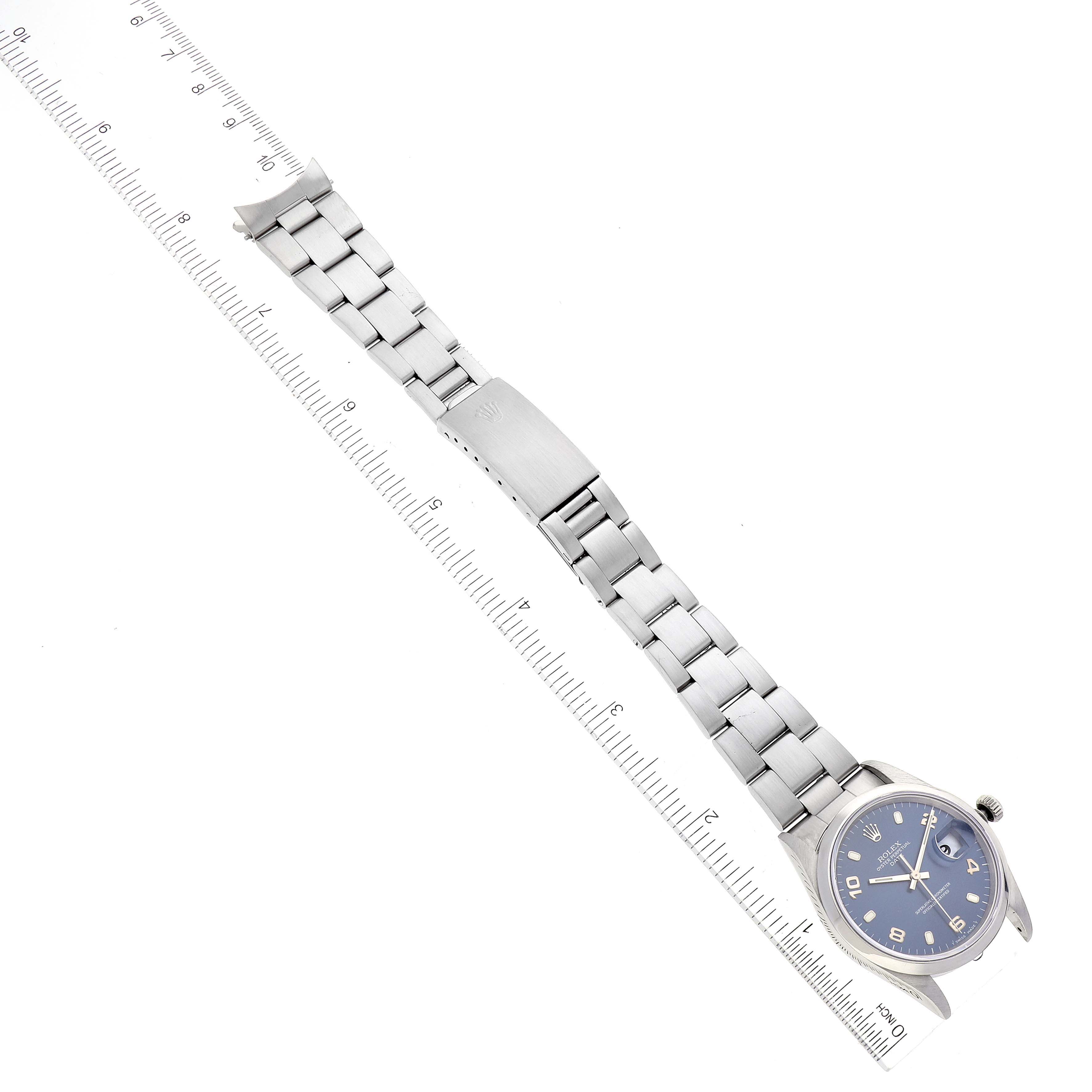 The image shows a top-down angle of a Rolex Date 15200 Men
s Stainless Steel Blue Dial 15200 Men
s Stainless Steel Blue Dial model watch, showcasing the entire band and face next to a ruler for scale.