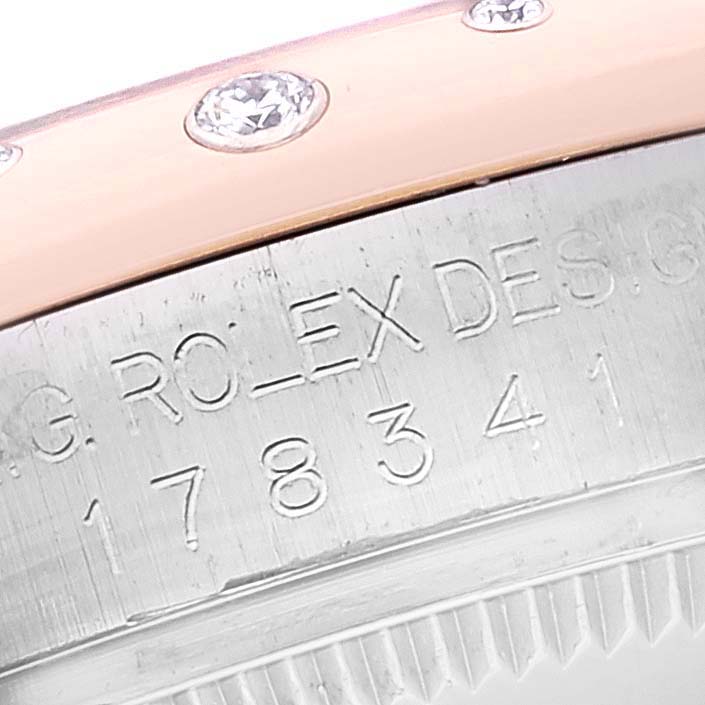 The image shows a close-up of a Rolex Mid-Size 178341 Women
s Steel and Gold (two tone) Mother of Pearl Dial 178341 Women
s Steel and Gold (two tone) Mother of Pearl Dial model, highlighting the engraved bezel and diamond accents.