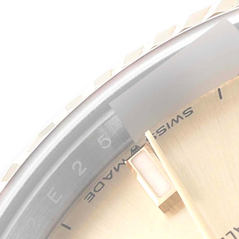 The image shows a close-up of the bezel, part of the dial, and hour markers of a Mid-Size Rolex watch.