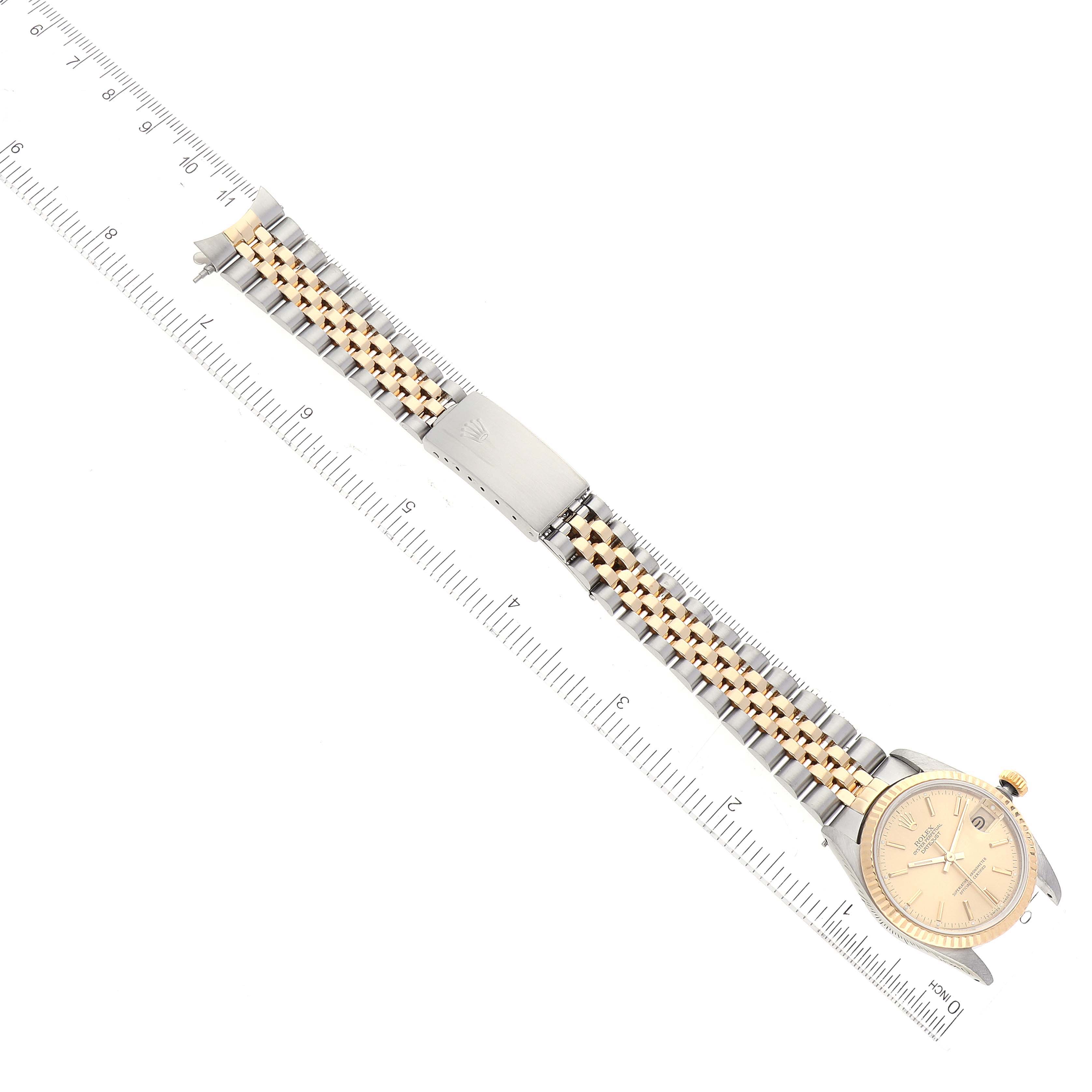 The Rolex Mid-Size 68273 Women
s Steel and Gold (two tone) Champagne Dial 68273 Women
s Steel and Gold (two tone) Champagne Dial watch is shown from an overhead angle, displaying the full band, face, and a clasp with the logo.