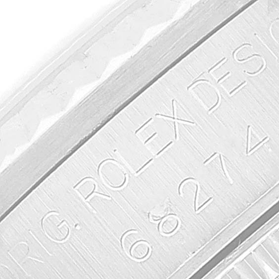 The image shows an engraved part of a Mid-Size Rolex watch case or bezel, displaying its model number and "ROLEX DESIGN."
