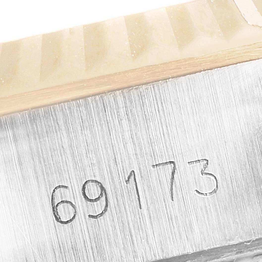 This close-up image shows the engraved serial number "69173" on a Rolex Datejust 69173 Women's Steel and Gold (two tone) Black Dial 69173 Women's Steel and Gold (two tone) Black Dial watch, focusing on the case and fluted bezel.