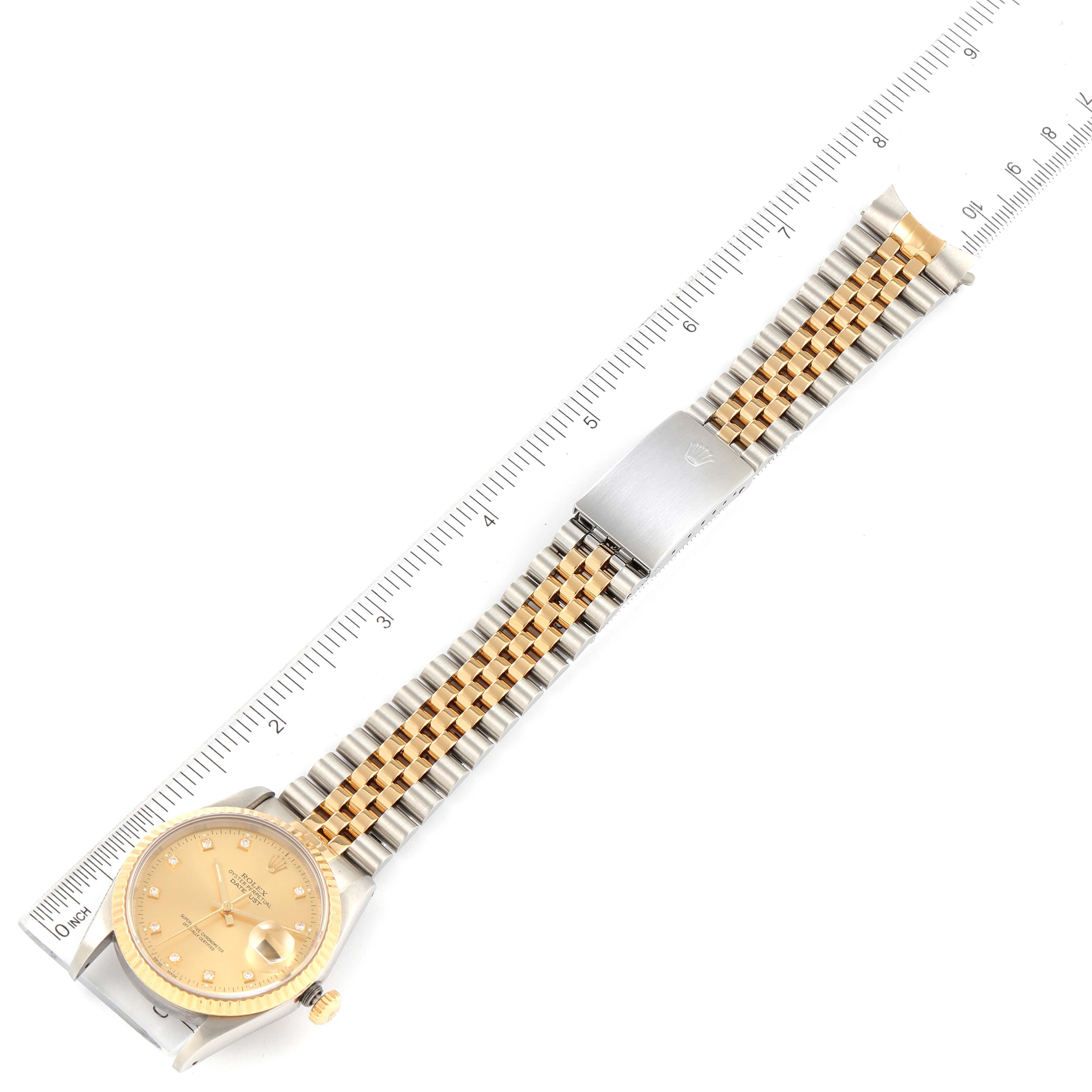The Rolex Datejust 16233 Men
s Steel and Gold (two tone) Champagne Dial watch is shown from a top view, displaying the face, band, clasp, and a measuring ruler alongside.