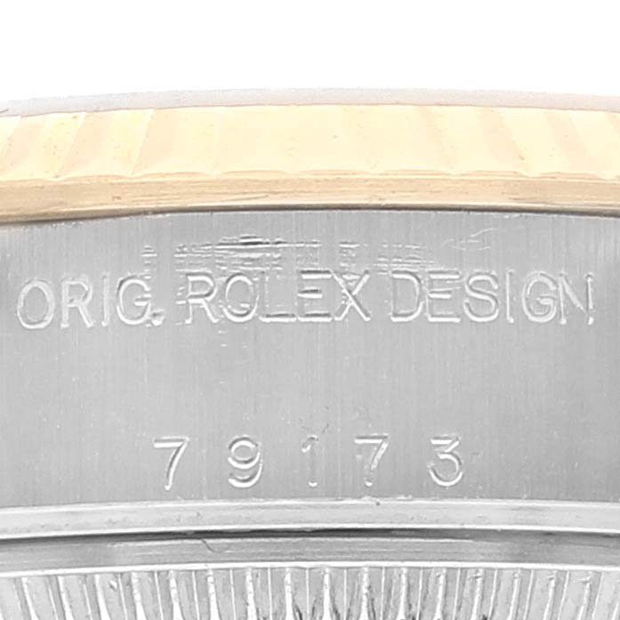 The image shows the side of the case and the edge of the bezel of a Rolex Datejust 79173 Women's Steel and Gold (two tone) Champagne Dial 79173 Women's Steel and Gold (two tone) Champagne Dial watch with its design number engraved.