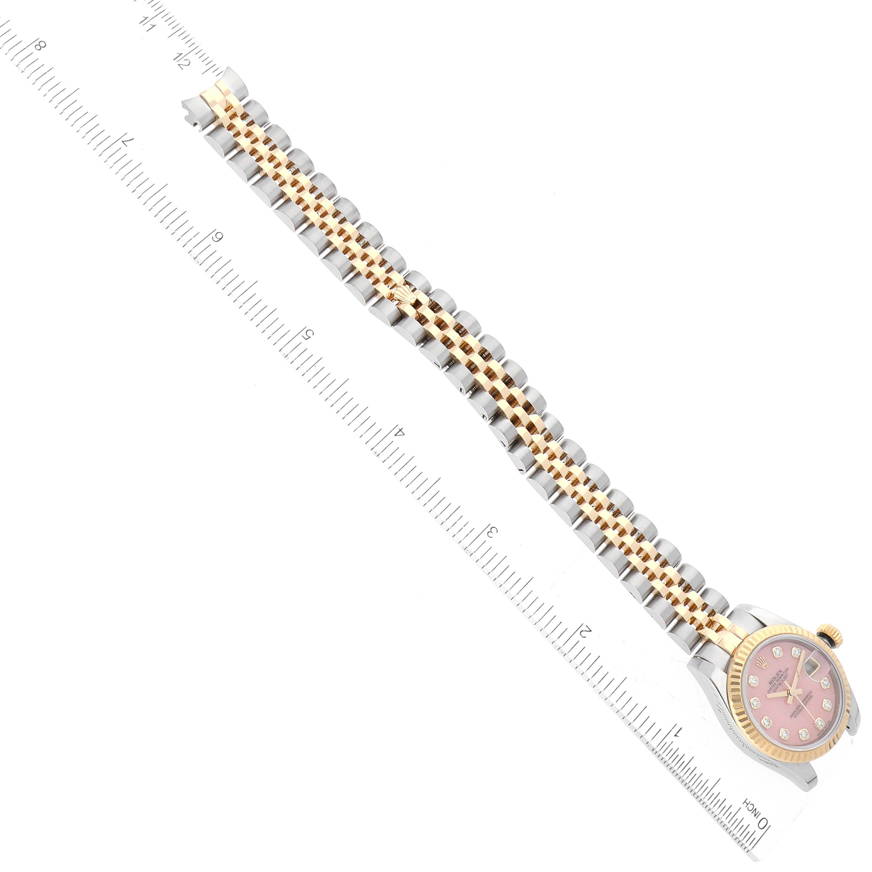 The image shows a Rolex Datejust 179173 Women's Steel and Gold (two tone) Pink Dial 179173 Women's Steel and Gold (two tone) Pink Dial watch lying flat, showcasing its dial, bezel, and two-tone bracelet, with a ruler beside it for scale.