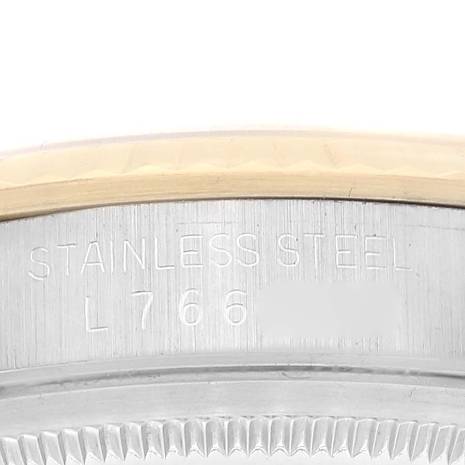 This close-up image shows the side of a Rolex Datejust 16233 Men's Steel and Gold (two tone) Champagne Dial 16233 Men's Steel and Gold (two tone) Champagne Dial watch, highlighting the stainless steel engraving and part of the bezel.