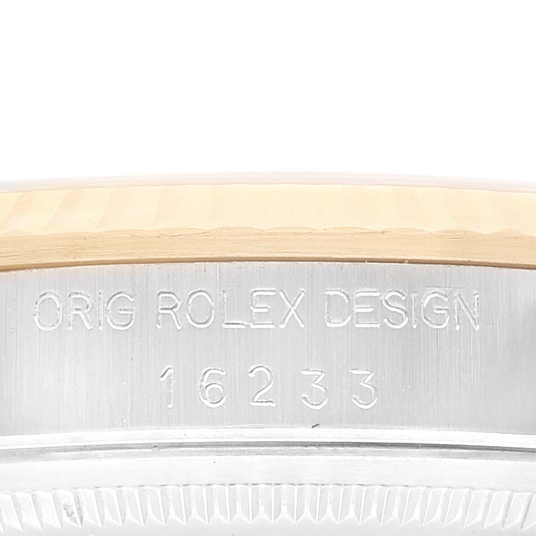 The image shows a close-up of the engraving on the side of a Rolex Datejust 16233 Men's Steel and Gold (two tone) Champagne Dial 16233 Men's Steel and Gold (two tone) Champagne Dial model watch's case, displaying its design and model number.