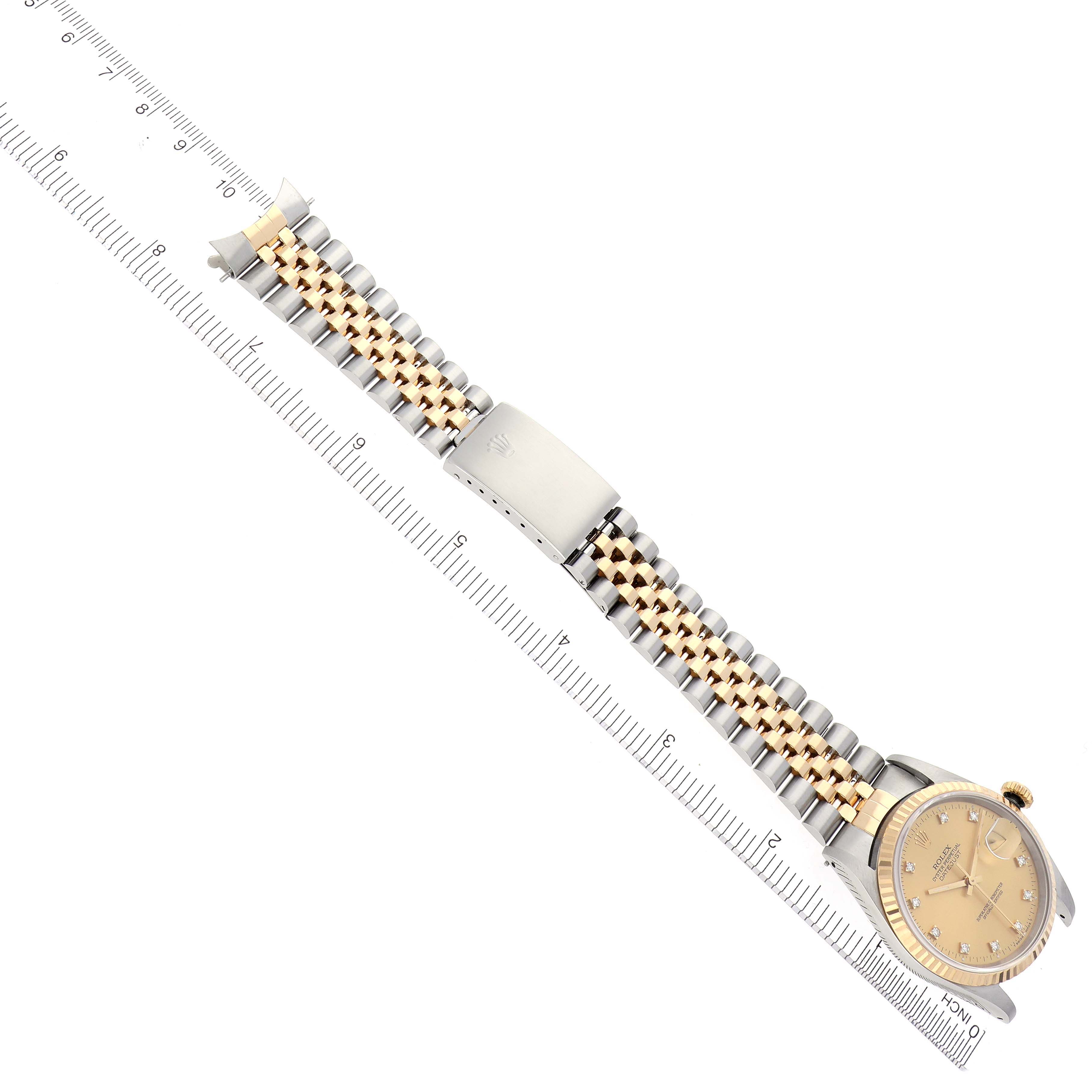 The Rolex Datejust 16233 Men's Steel and Gold (two tone) Champagne Dial 16233 Men's Steel and Gold (two tone) Champagne Dial is shown from a top-down angle, displaying the full bracelet and face next to a ruler for scale.