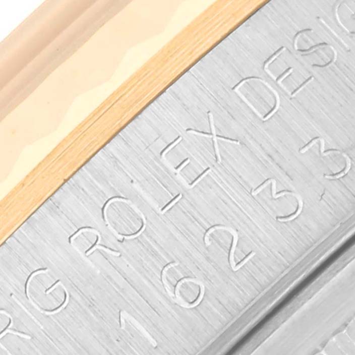 The image shows a close-up of the Rolex Datejust 16233 Men's Steel and Gold (two tone) Champagne Dial 16233 Men's Steel and Gold (two tone) Champagne Dial watch case side with engraved text.