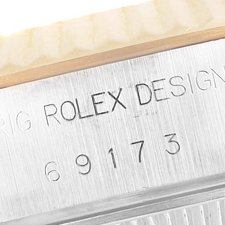 The image shows a close-up of the side of a Rolex Datejust 69173 Women's Steel and Gold (two tone) Blue Dial 69173 Women's Steel and Gold (two tone) Blue Dial watch, highlighting the engraved model number and Rolex Design inscription.