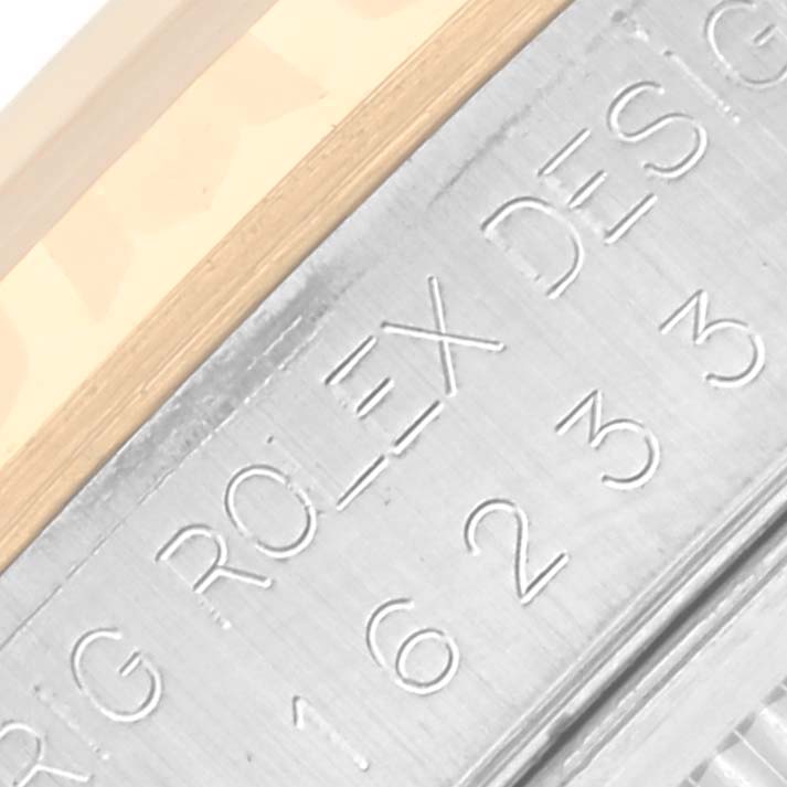 The image shows a close-up of the engraved side of a Rolex Datejust 16233 Men's Steel and Gold (two tone) White Dial 16233 Men's Steel and Gold (two tone) White Dial watch, focusing on the model number.