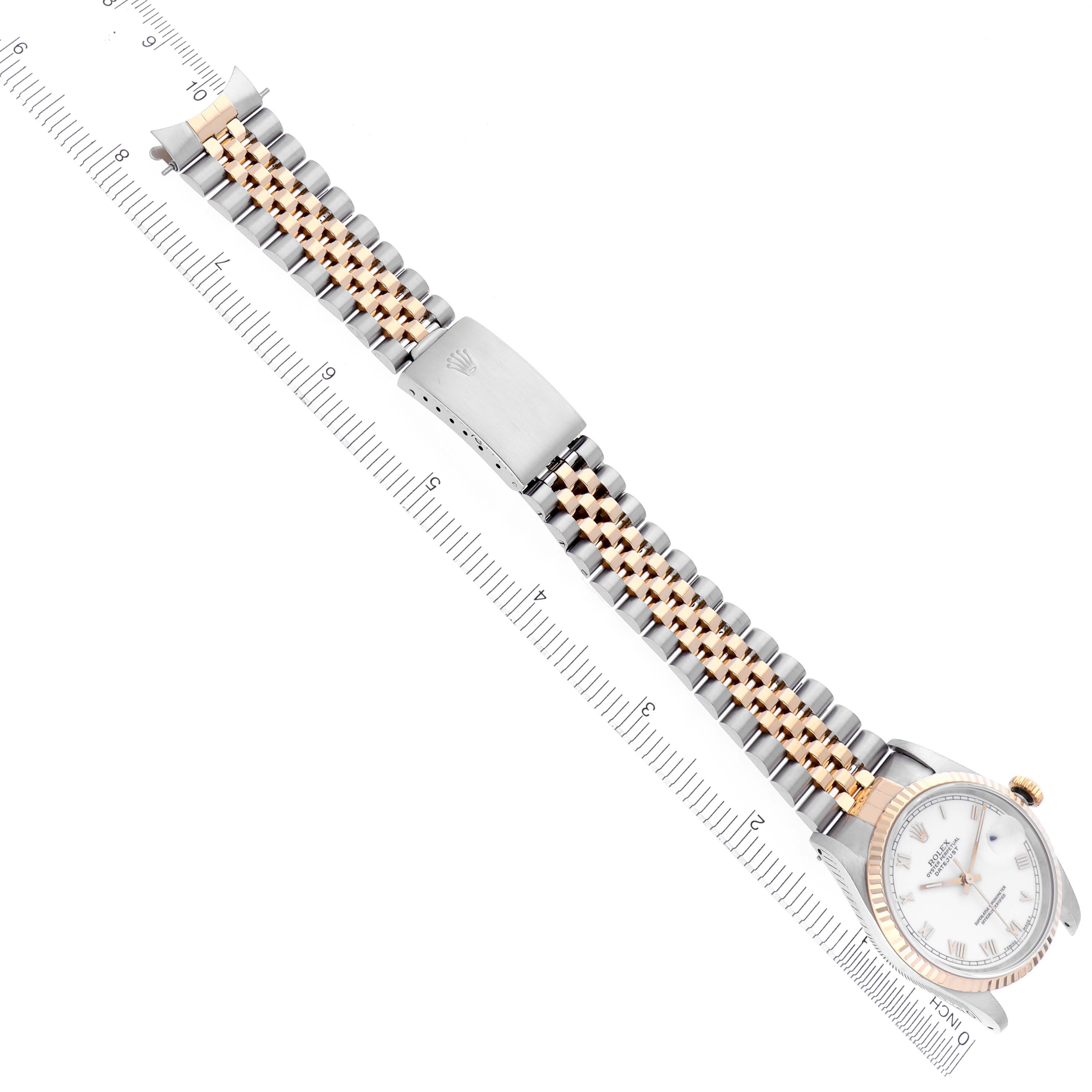 The Rolex Datejust 16233 Men's Steel and Gold (two tone) White Dial 16233 Men's Steel and Gold (two tone) White Dial watch is shown from an overhead angle, highlighting the bracelet and watch face alongside a ruler for size reference.