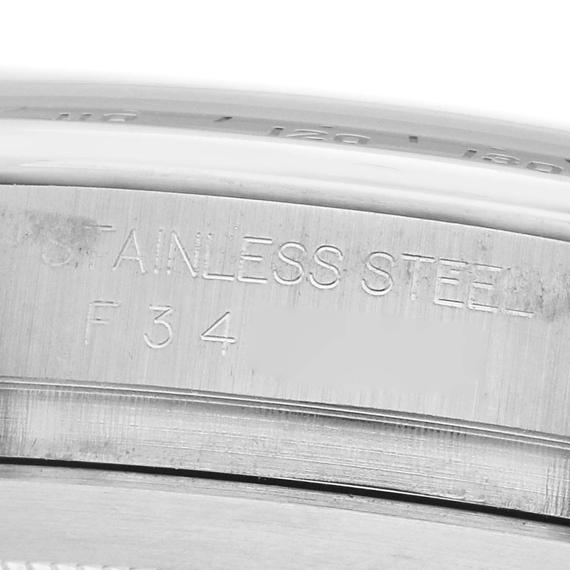 The image shows a close-up of the side of a Rolex Daytona 116520 Men's Stainless Steel Black Dial watch, highlighting the "STAINLESS STEEL" engraving.
