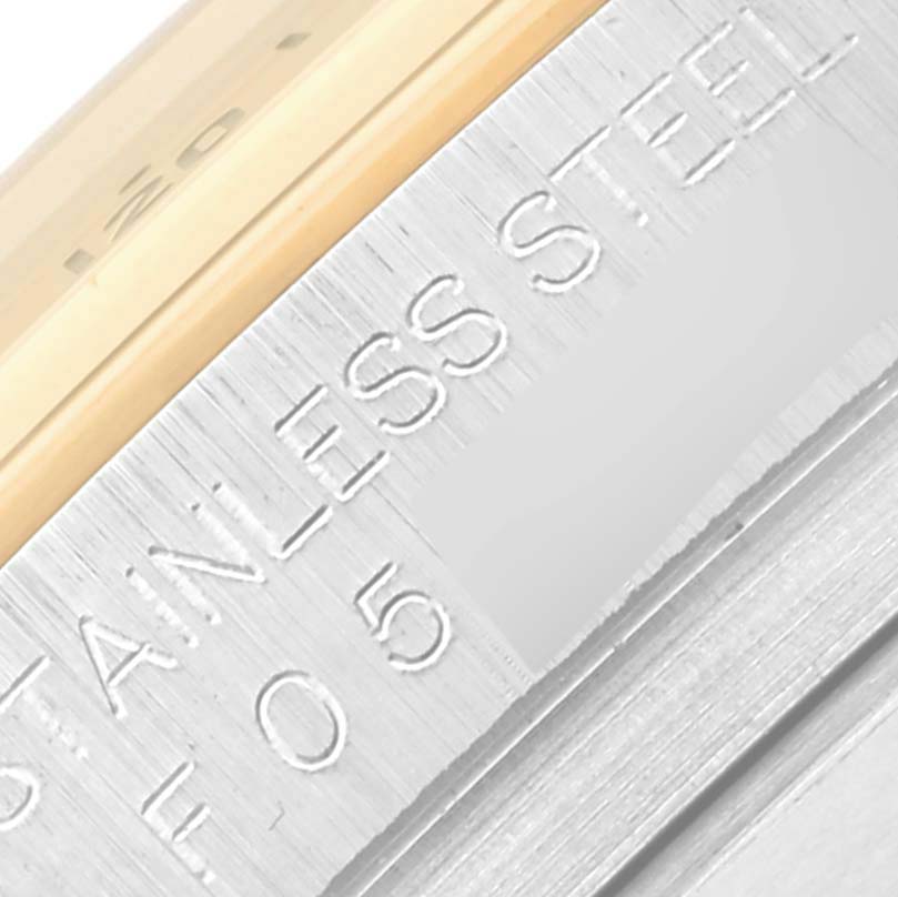 The image shows a close-up of the side engraving on the bezel of a Rolex Daytona 116523 Men's Steel and Gold (two tone) Black Dial 116523 Men's Steel and Gold (two tone) Black Dial watch, highlighting the material.