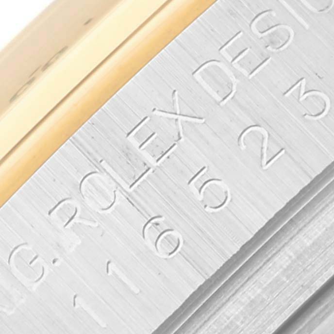 This close-up image shows the engraved side of the bezel on a Rolex Daytona 116523 Men's Steel and Gold (two tone) Black Dial 116523 Men's Steel and Gold (two tone) Black Dial watch.