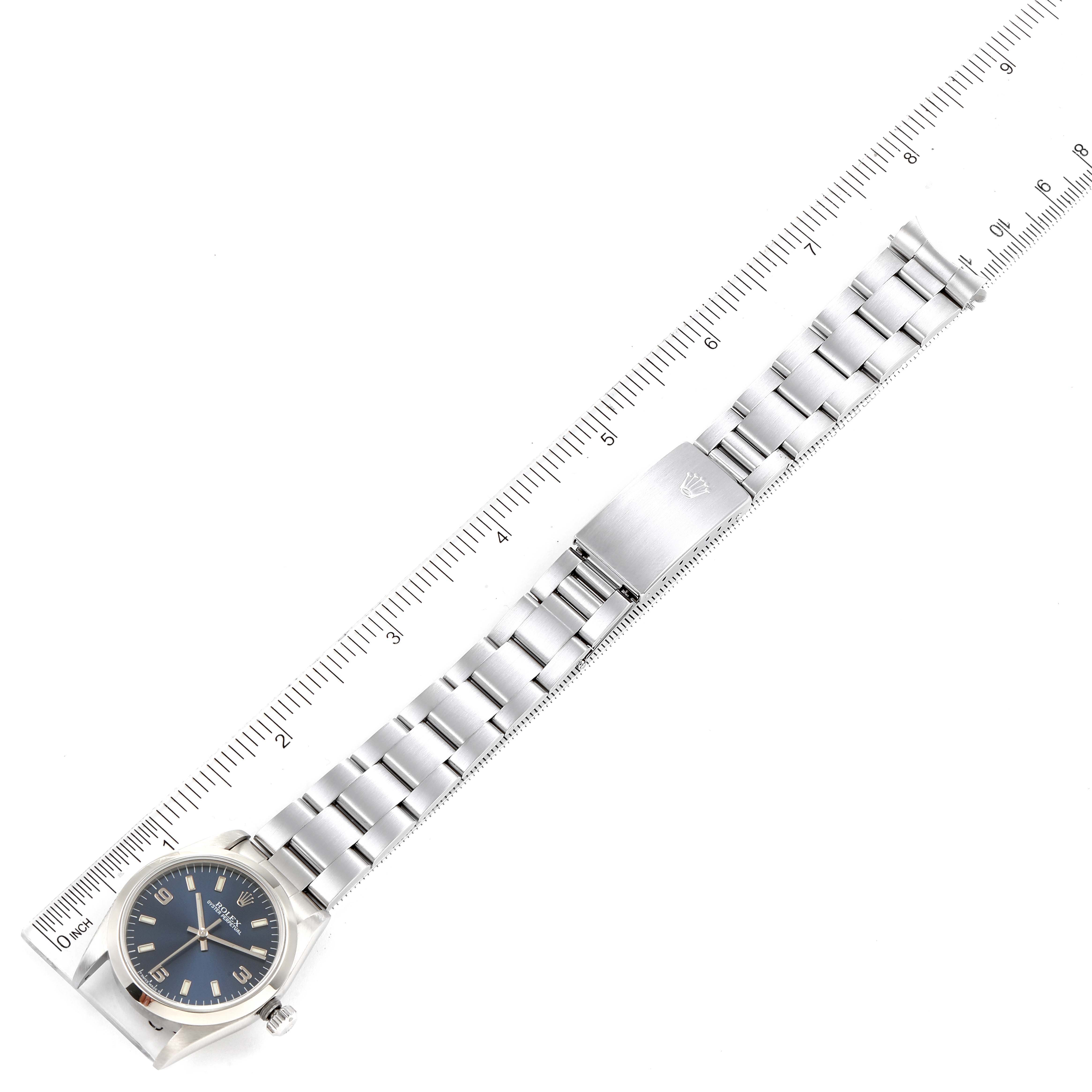 The Rolex Mid-Size 77080 Women
s Stainless Steel Blue Dial 77080 Women
s Stainless Steel Blue Dial model watch is shown from above along its entire length next to a ruler.