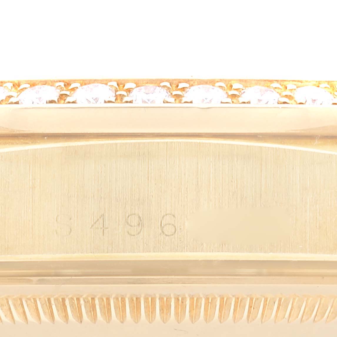 This image shows a close-up view of the side of a Rolex President 18348 Men
s Yellow Gold Champagne Dial 18348 Men
s Yellow Gold Champagne Dial watch case, highlighting the serial number and diamond bezel.