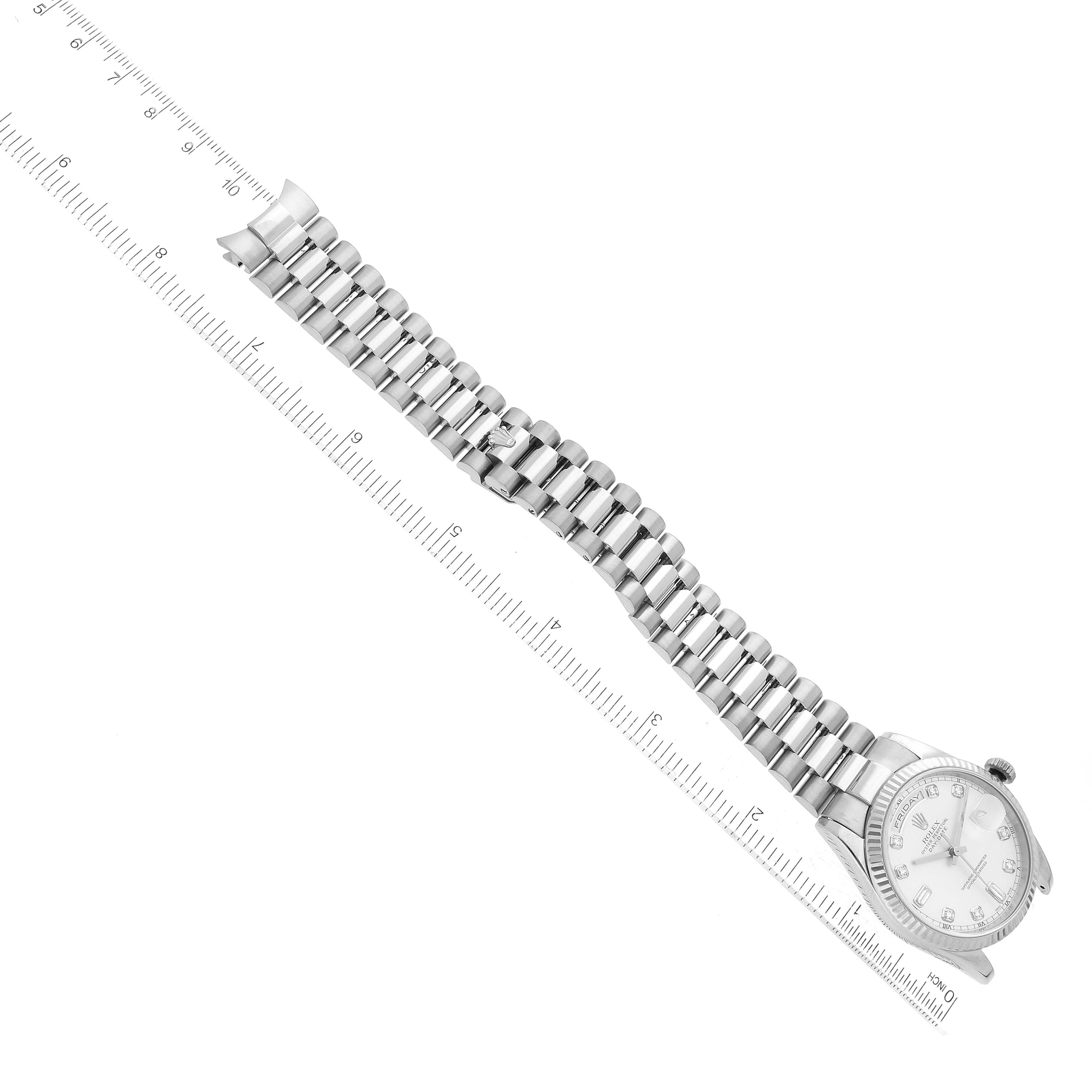 The Rolex President 118239 Men's White Gold Silver Dial model is shown from above, displaying its face, bracelet, and clasp alongside a ruler for scale.