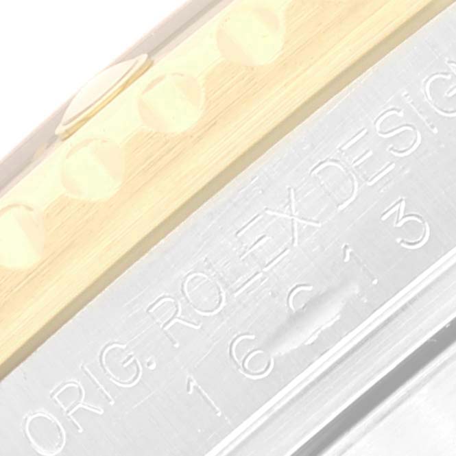 The image shows a close-up of the case side, bezel edge, and part of the engravings on a Rolex Submariner 16613 Men's Steel and Gold (two tone) Black Dial 16613 Men's Steel and Gold (two tone) Black Dial watch.