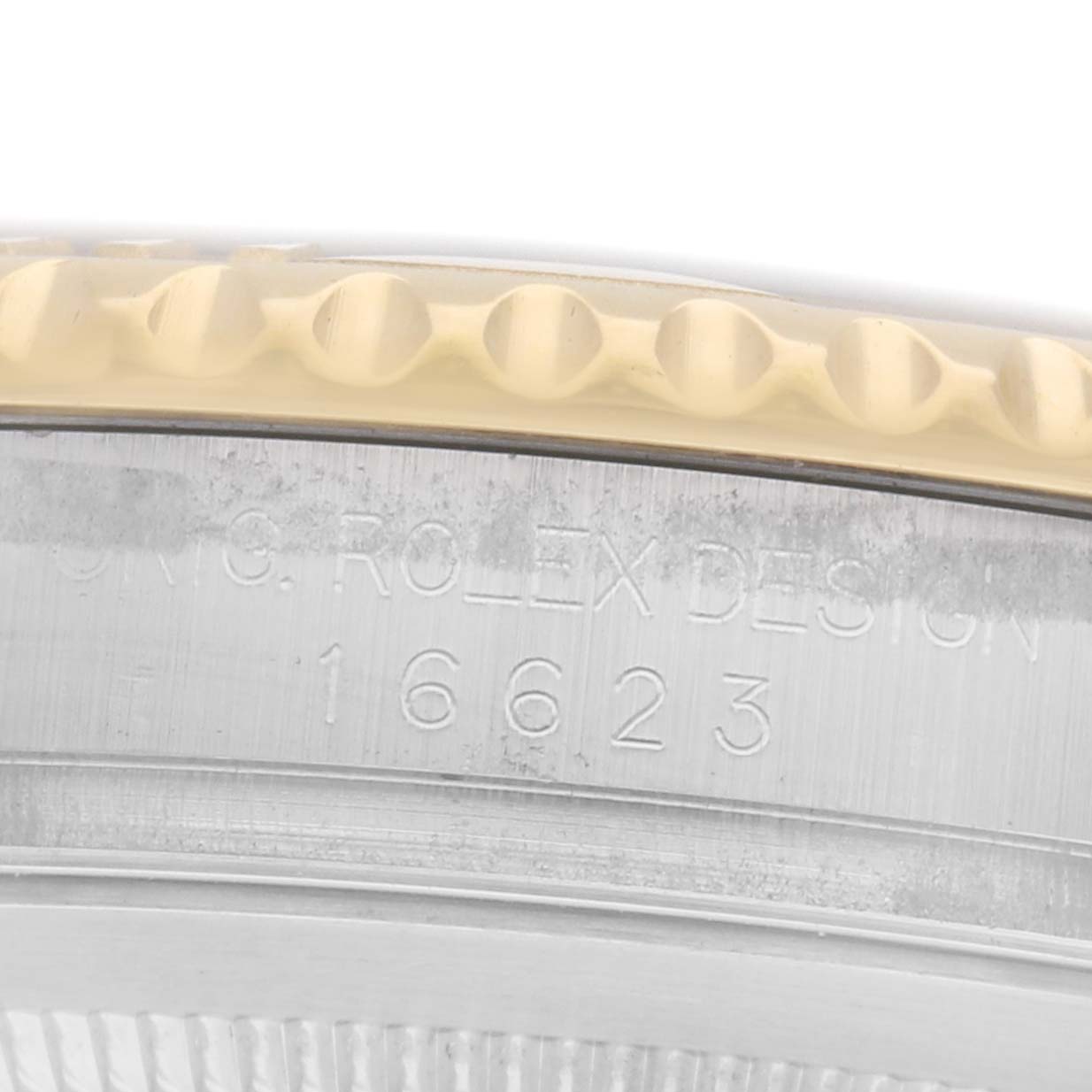 The image shows a close-up of the side of a Rolex Yacht-Master 16623 Men
s Steel and Gold (two tone) Champagne Dial watch, highlighting the bezel and etched model number "16623."