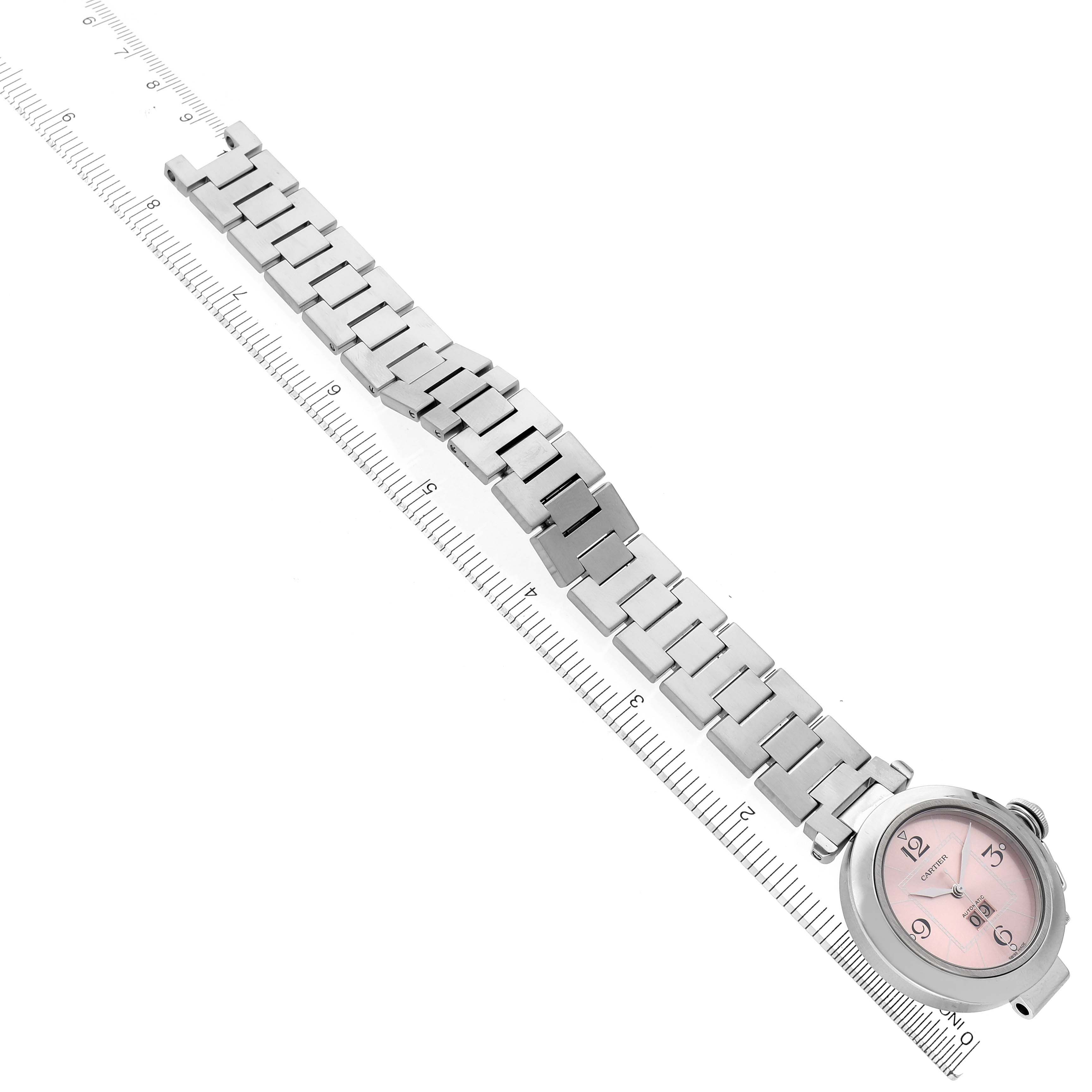 The Cartier Pasha W31058M7 Women's Stainless Steel Pink Dial W31058M7 Women's Stainless Steel Pink Dial watch is shown at an angled view, displaying the face and entire metal bracelet alongside a ruler for scale.