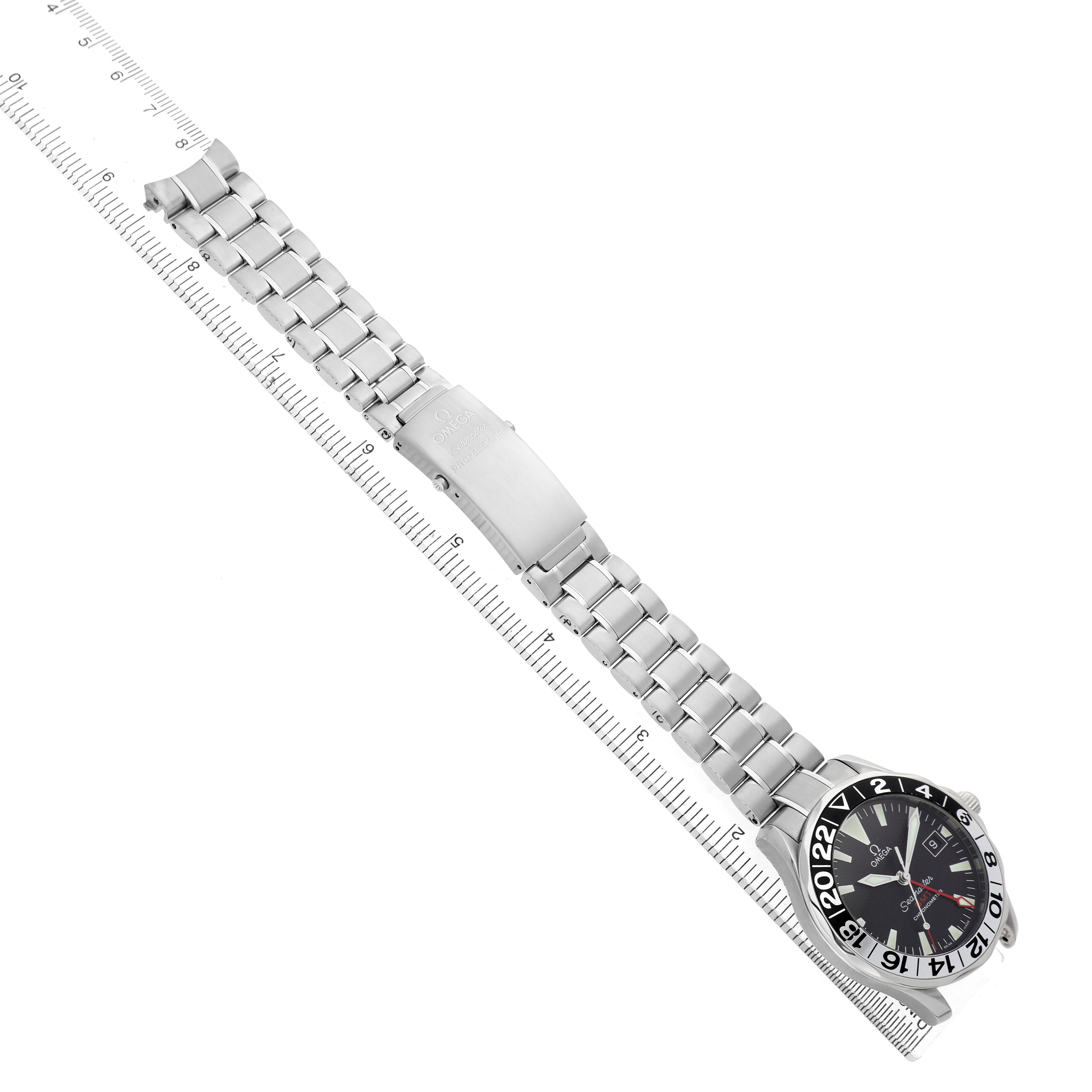 The Omega Seamaster 2234.50.00 Men's Stainless Steel Black Dial watch is shown diagonally with its full bracelet and clasp visible, alongside a ruler for scale.