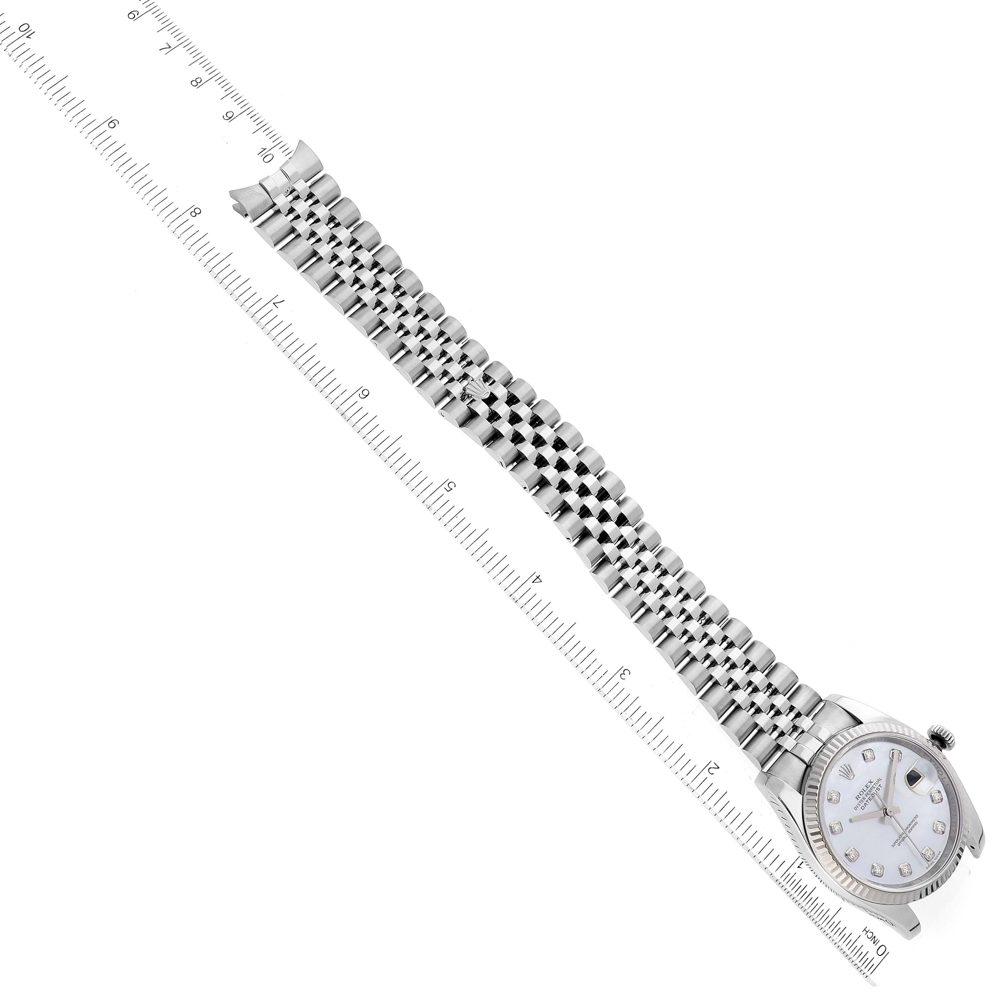 The Rolex Datejust 116234 Men's Stainless Steel Mother of Pearl Dial 116234 Men's Stainless Steel Mother of Pearl Dial watch is shown from a top-down angle, displaying its face, bezel, and full metal bracelet alongside a ruler.