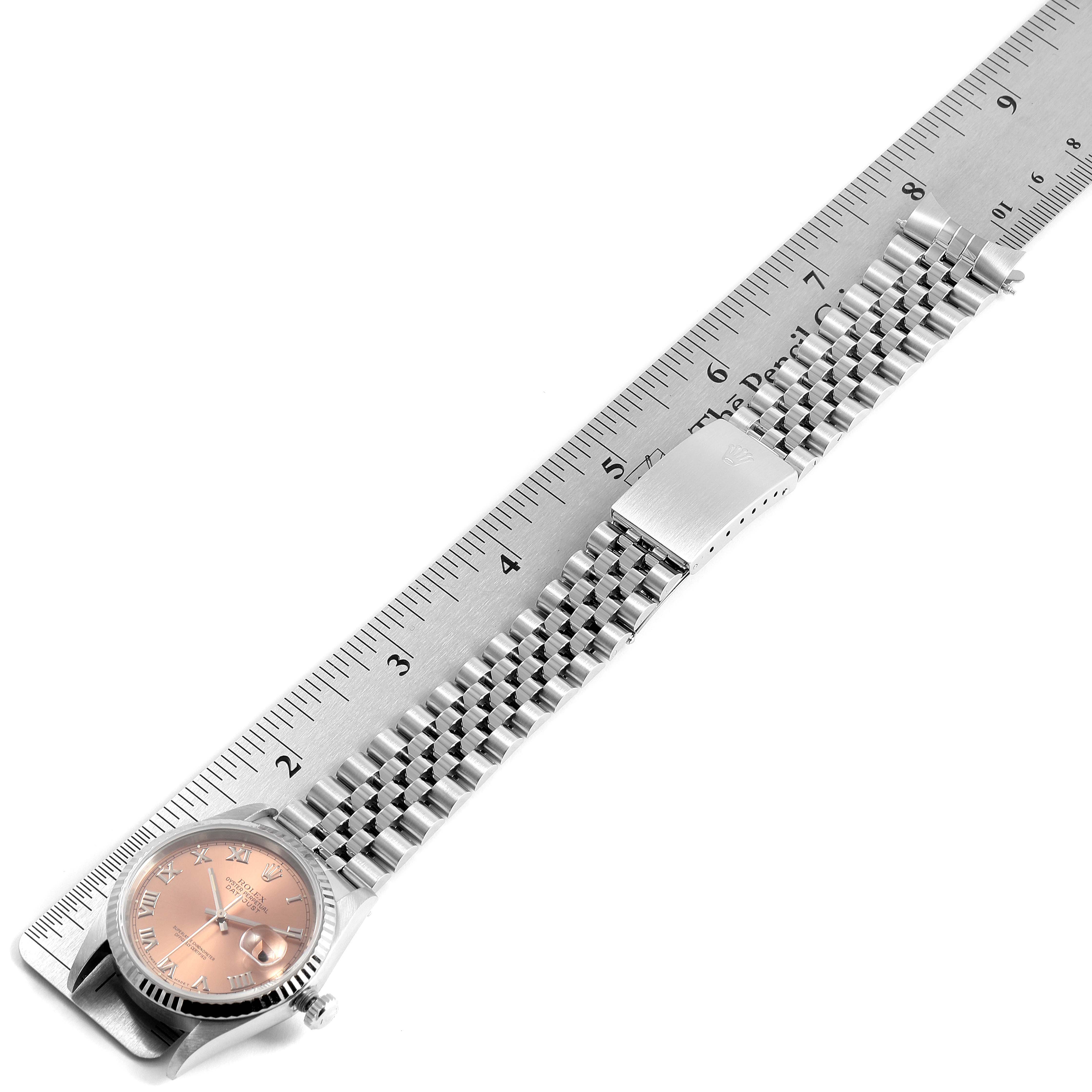 The image shows a Rolex Datejust 16234 Men's Stainless Steel Pink Dial 16234 Men's Stainless Steel Pink Dial watch from a top-down angle, including the face, bracelet, and clasp along with a ruler for measurement.